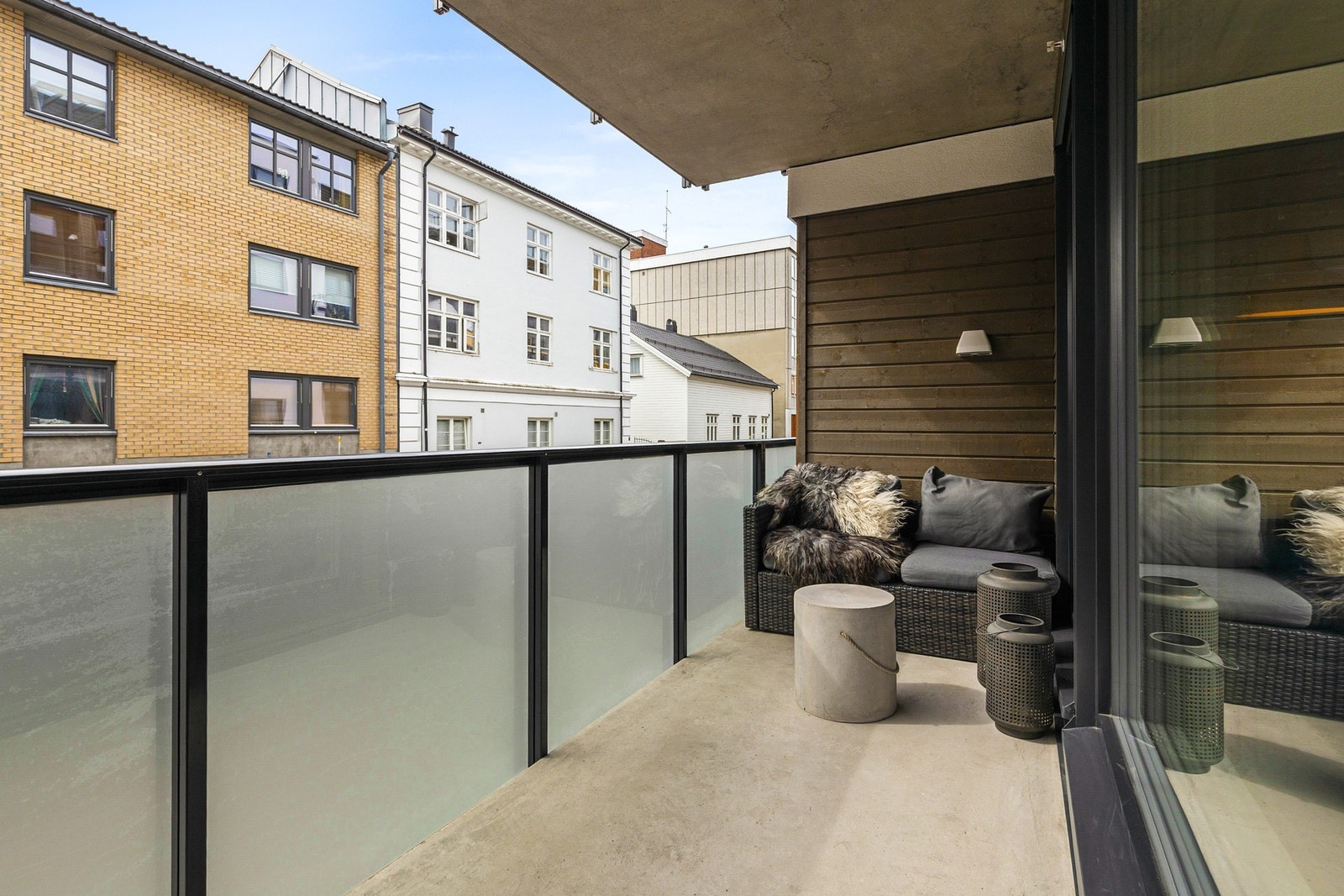 Balkongen har gulvflate av synlig betong og rekkverk av glass og metall Galleribilde