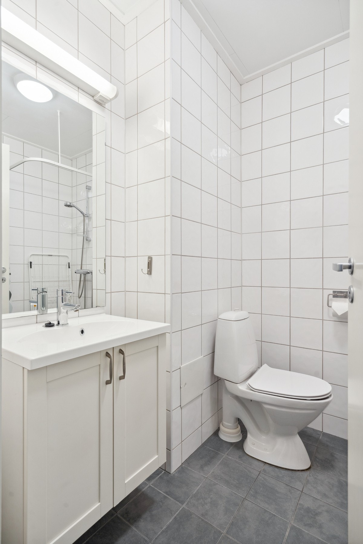 Badet har innredning med vegghengt servant og lyse farger Galleribilde