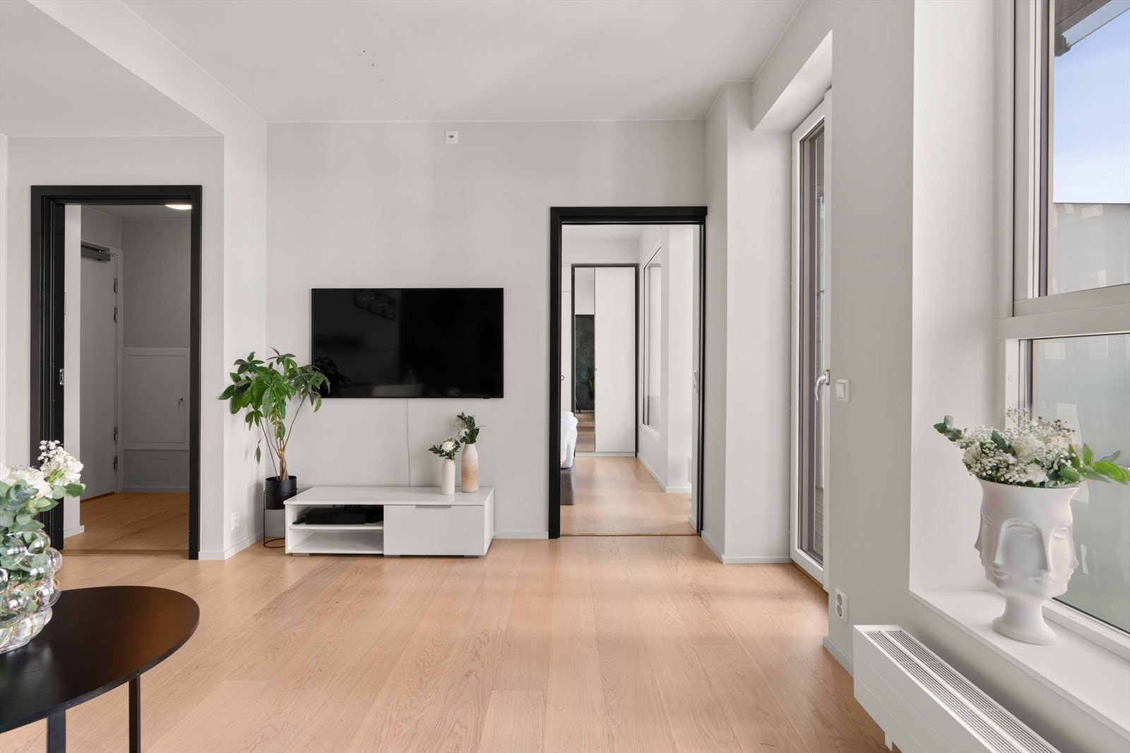 Stuen har en minimalistisk design med rene linjer og nøytrale farger, noe som skaper en varm og innbydende atmosfære. Galleribilde