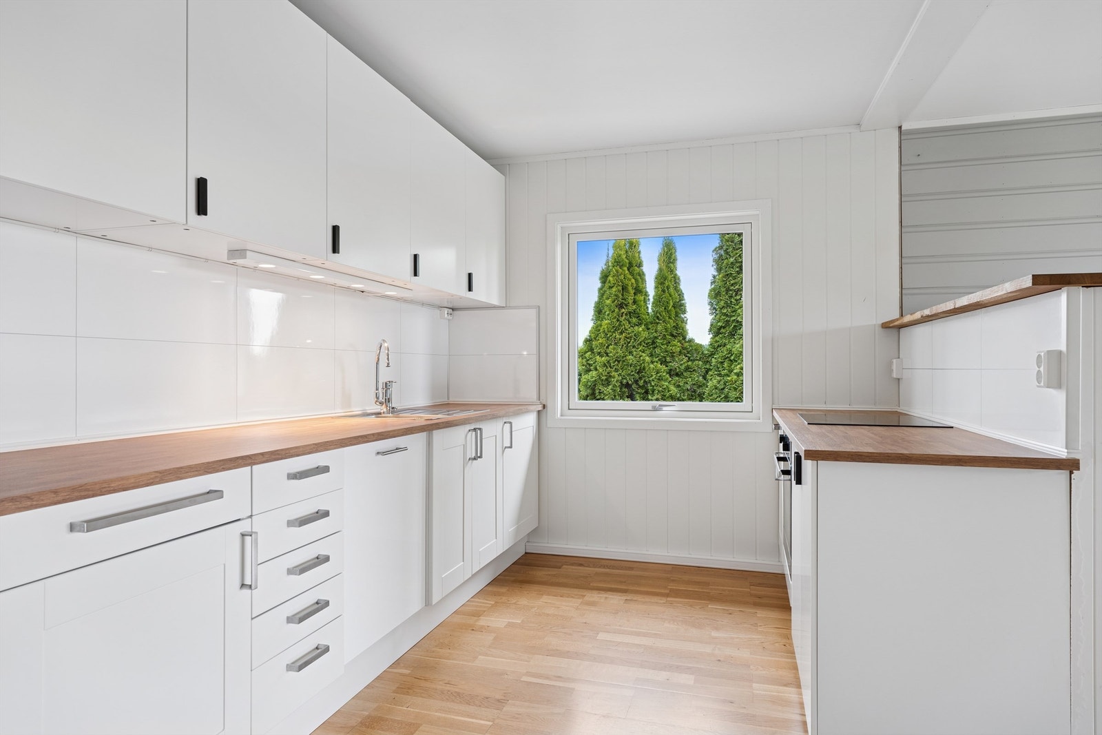 Kjøkkenet har innredning fra 2017 med glatte og profilerte fronter, benkeplate i laminat og godt med skap- og benkeplass. Galleribilde