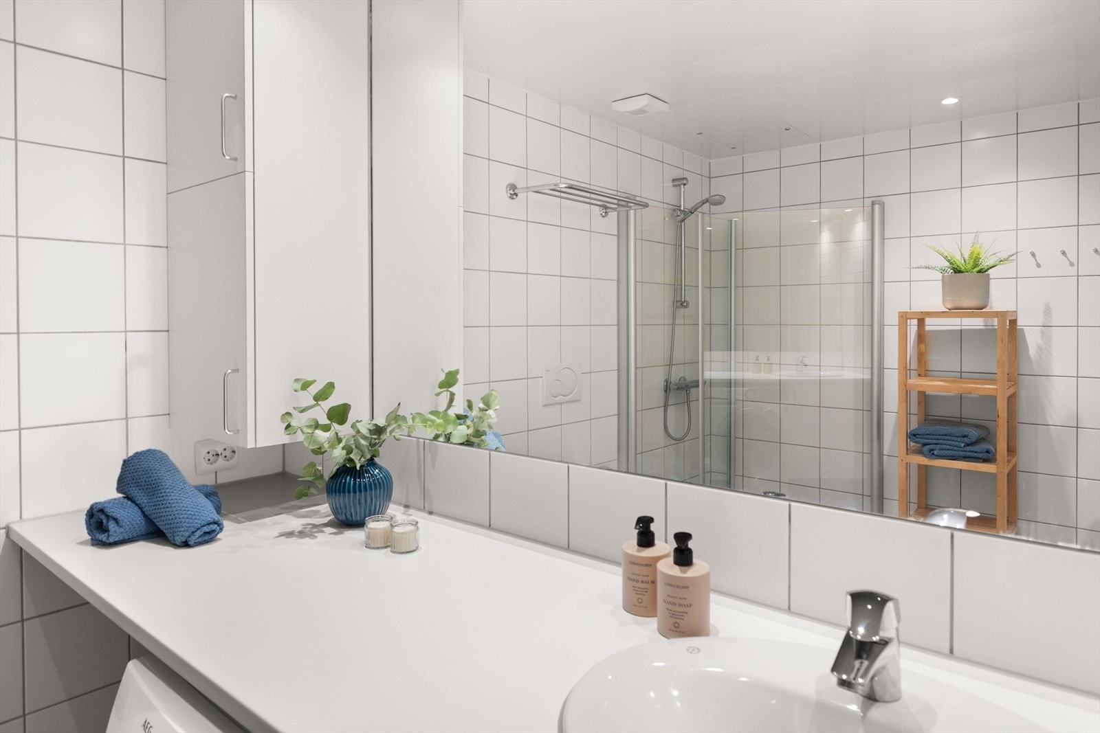 Badet er innredet med servantskap, toalett, dusjsone og opplegg for vaskemaskin og tørketrommel Galleribilde