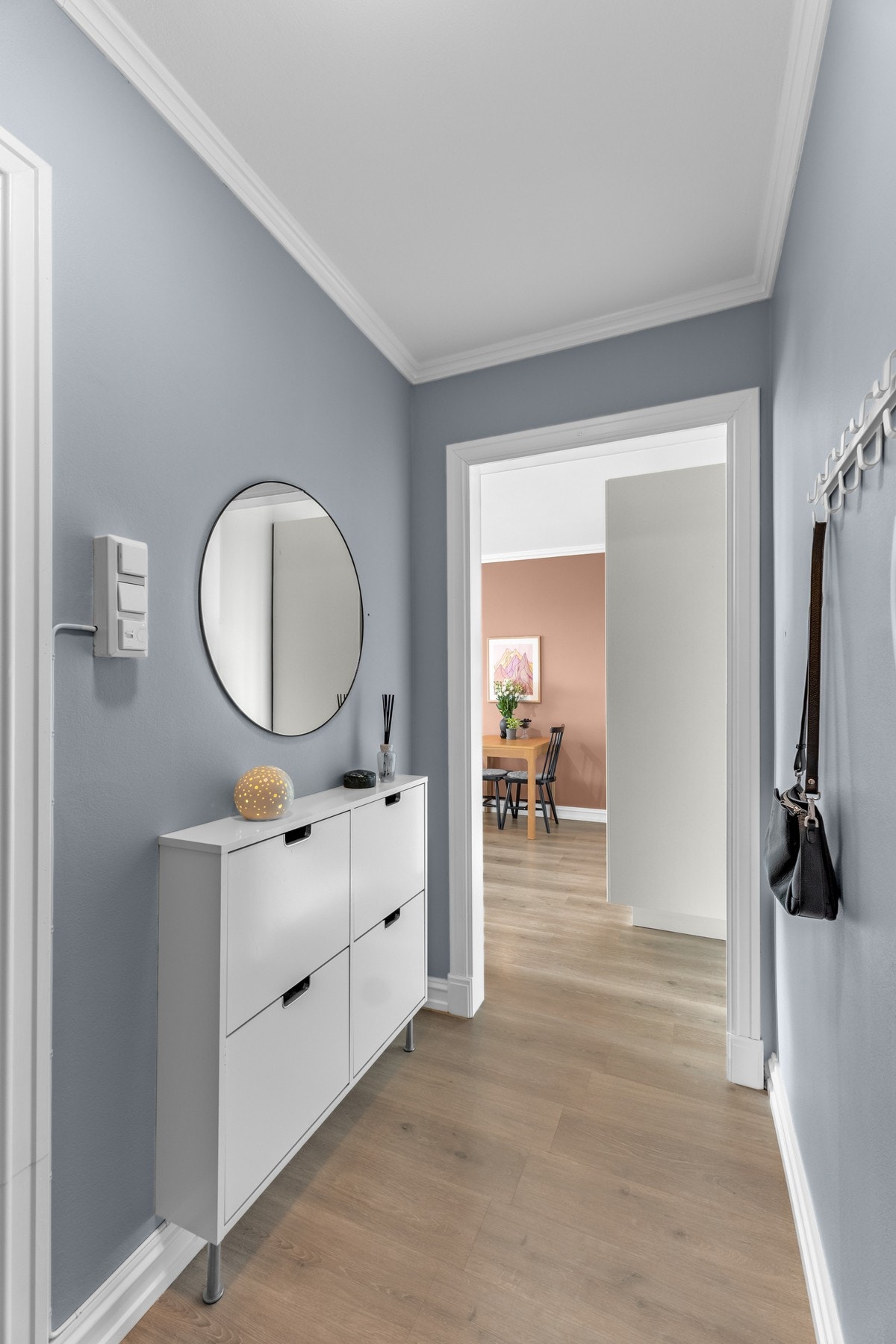 Lys og innbydende entré med blå vegger og plass til det du trenger for en varm velkomst. Galleribilde