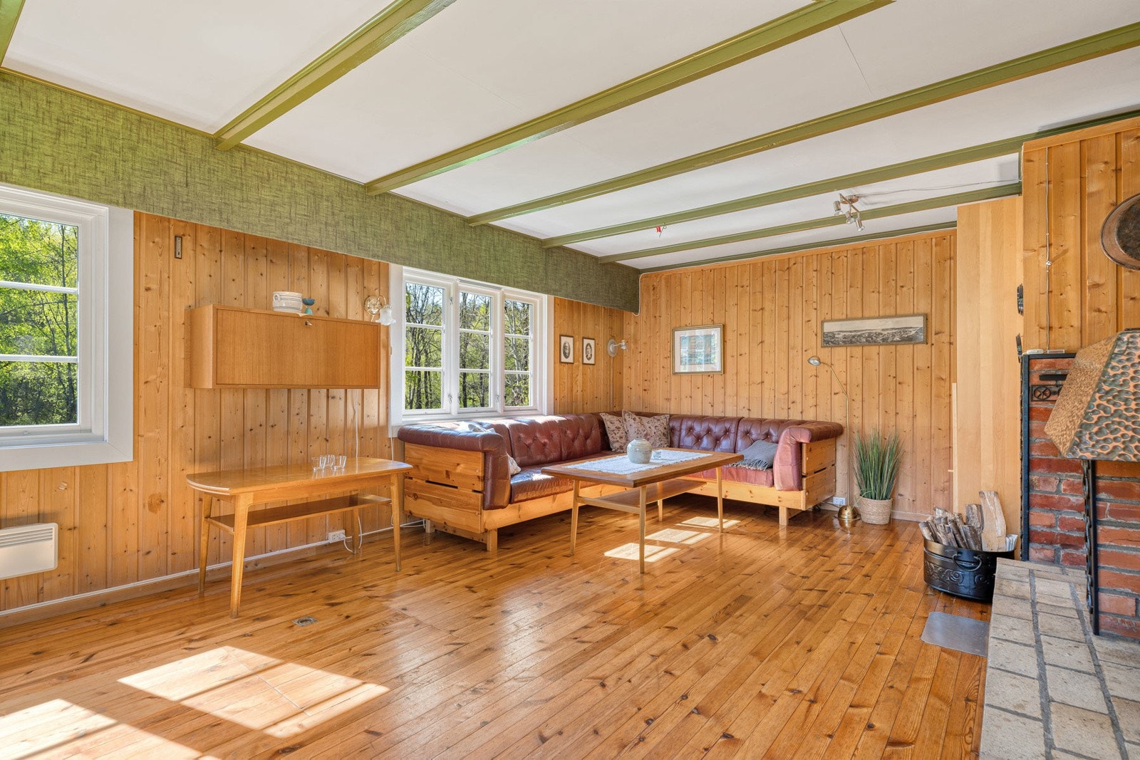 God plass for en stor sofa, TV-benk og spisebord. Mange vinduer som gir mye naturlig lys. Galleribilde