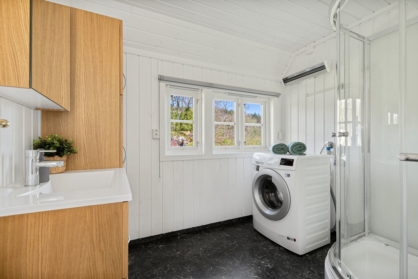 Badet har dusjkabinett og opplegg for vaskemaskin. Galleribilde