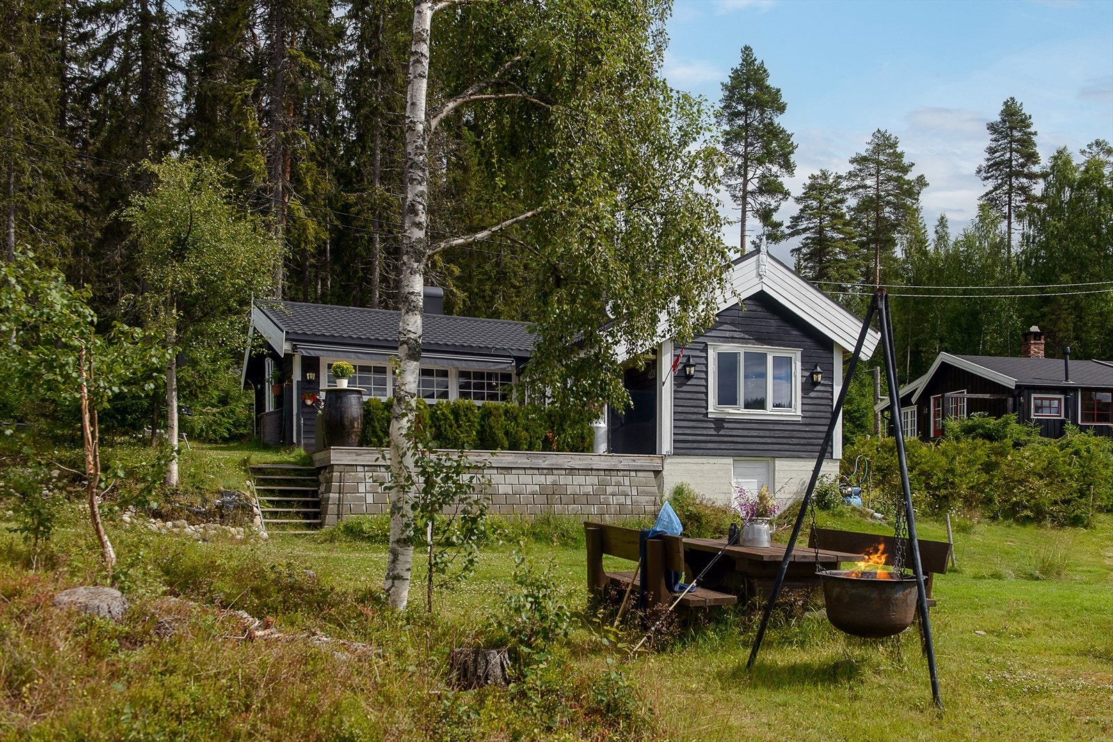 Benk og bålplass innbyr til å ta måltidet utendørs. Galleribilde