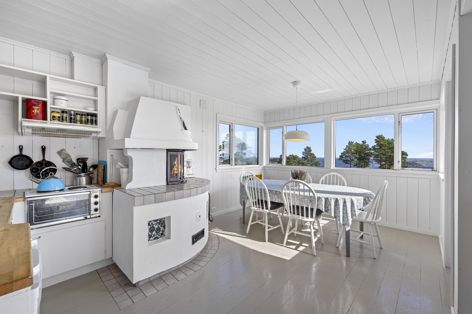 Kjøkken med plassbygd innredning og koselig peis. Galleribilde