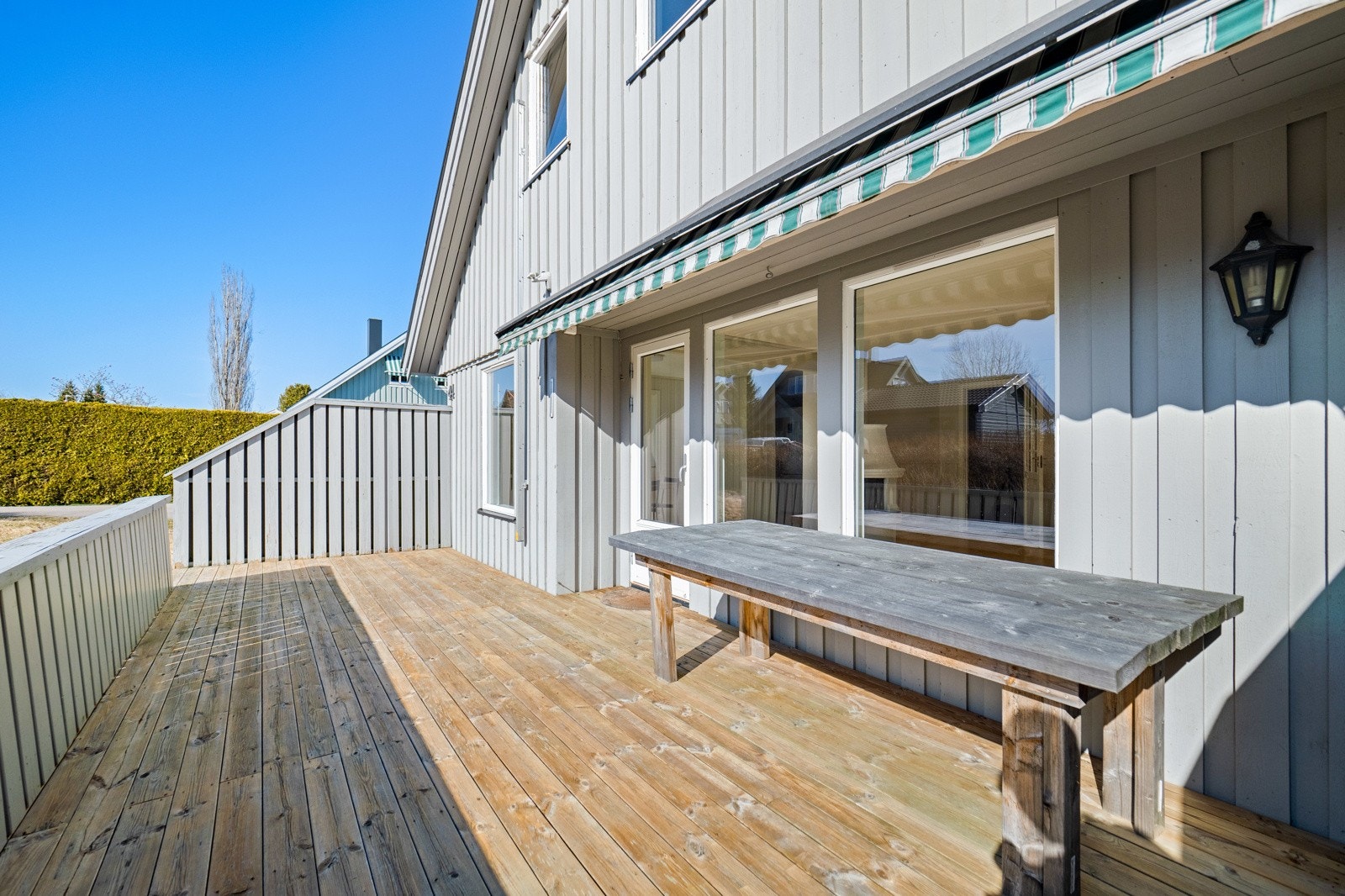 Den sydvestvendte terrassen er en lun og solrik sone med markise, levegger og god plass til utemøbler. Galleribilde