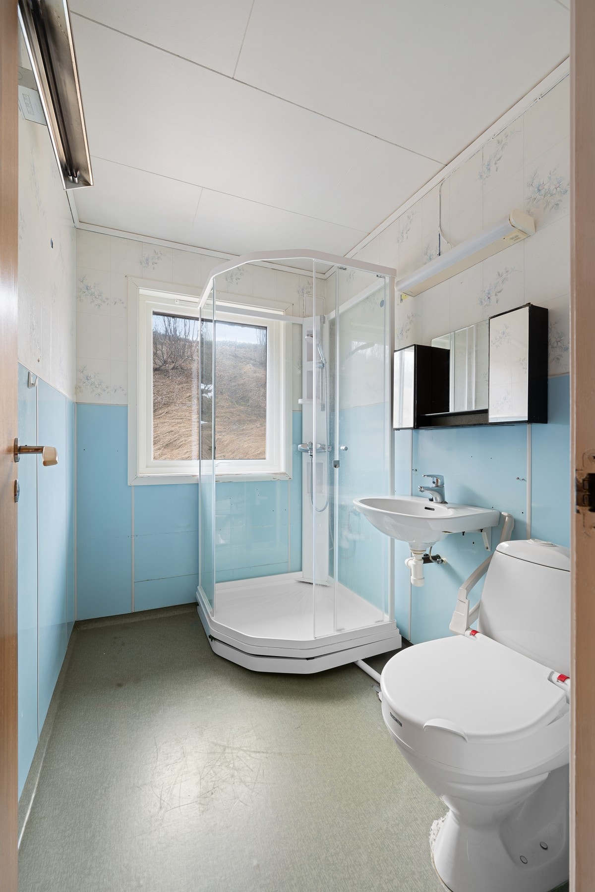 Badet inneholder servant, speilskap, dusjkabinett og toalett Galleribilde