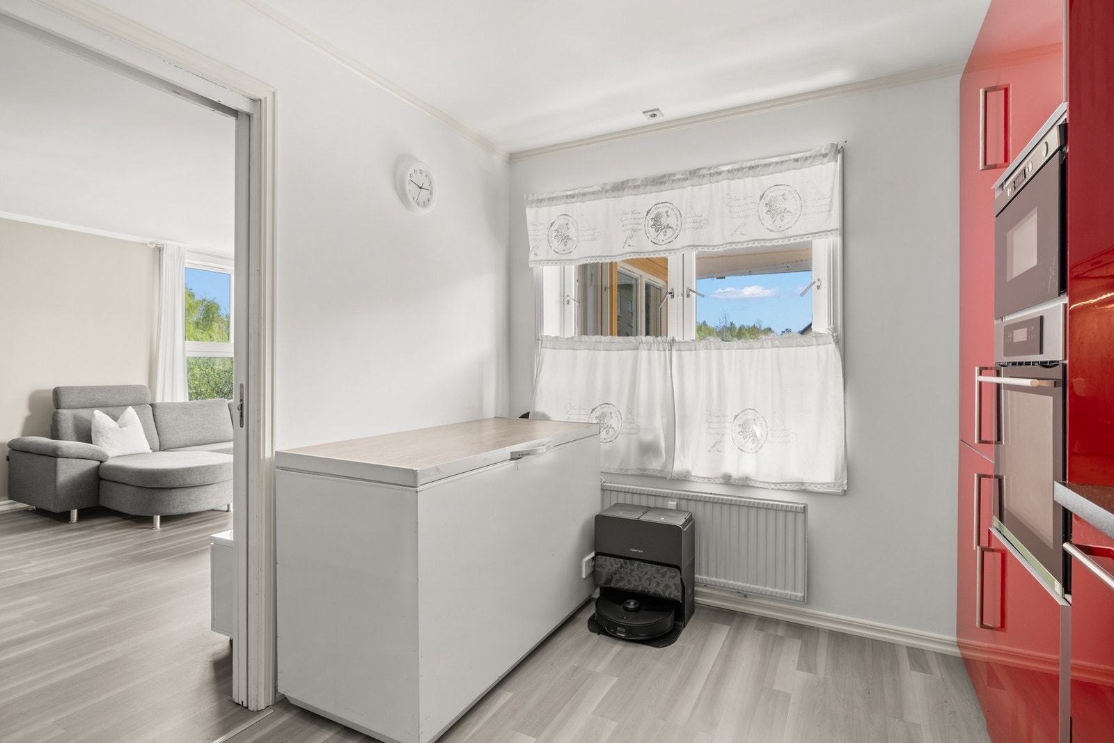 Kjøkkenet har en praktisk utforming som gir godt med både benke- og skapplass. Det er også plass til et lite spisebord eller ekstra oppbevaringsmøbel, noe som gjør kjøkkenet funksjonelt og effektivt i hverdagen. Galleribilde