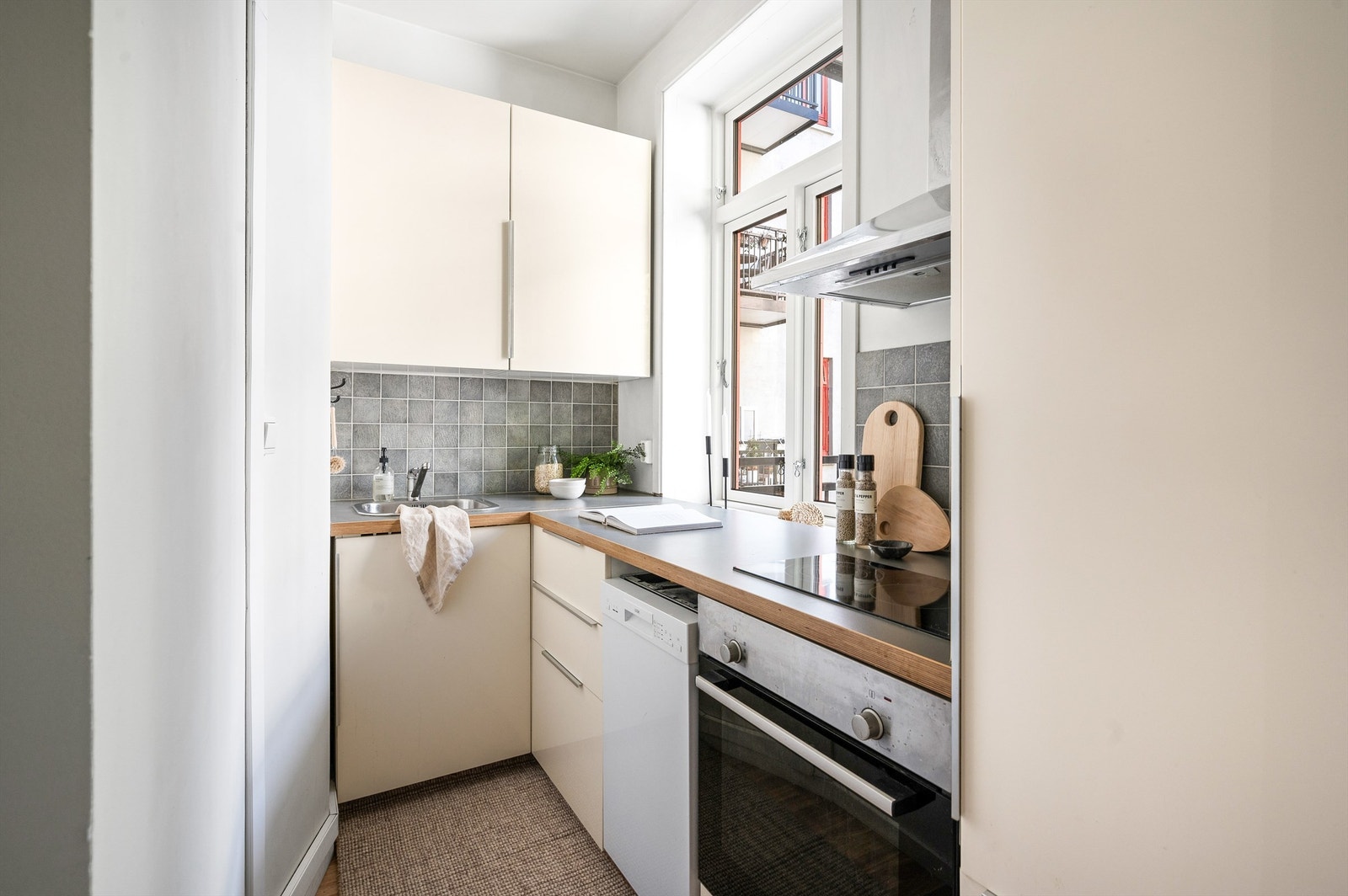 Sjarmerende kjøkken i egen sone foran vinduet mot bakgården, i delvis åpen løsning til stuen. Galleribilde