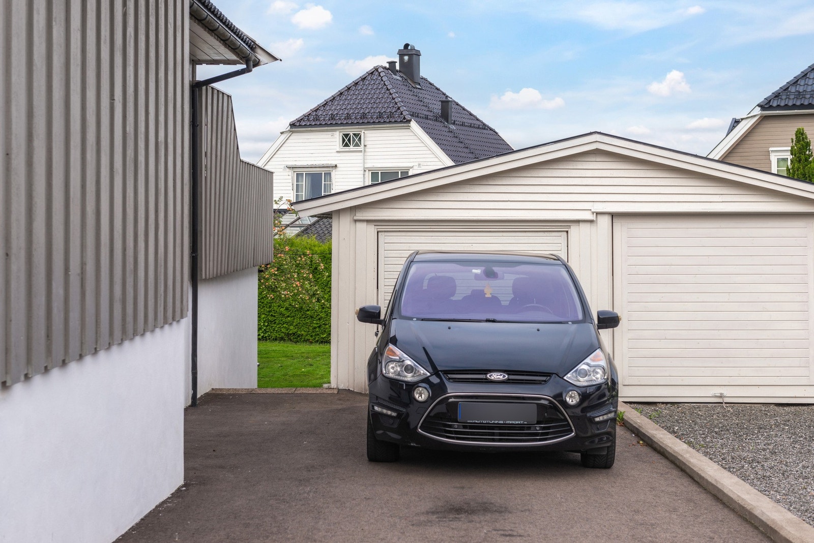 Eiendommen har delt garasje med naboen. Det er plass til flere biler i gårdsplass. Galleribilde