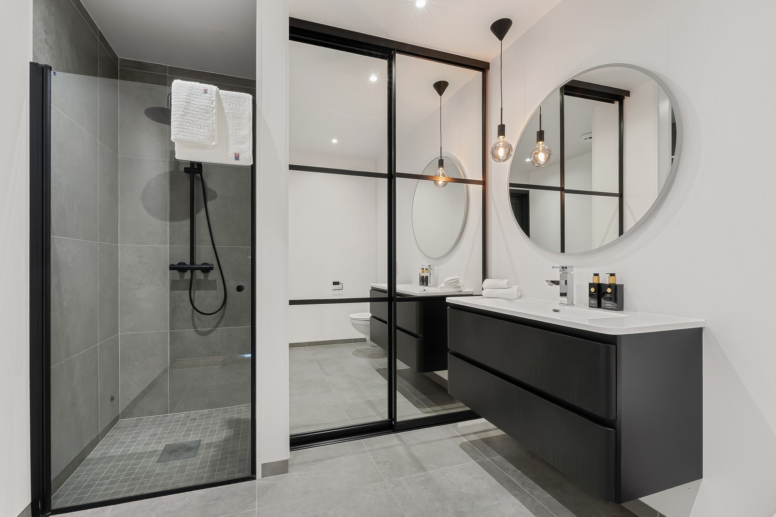 Moderne bad. Bak skyvedørene er det opplegg for vaskemaskin og tørketrommel. Galleribilde