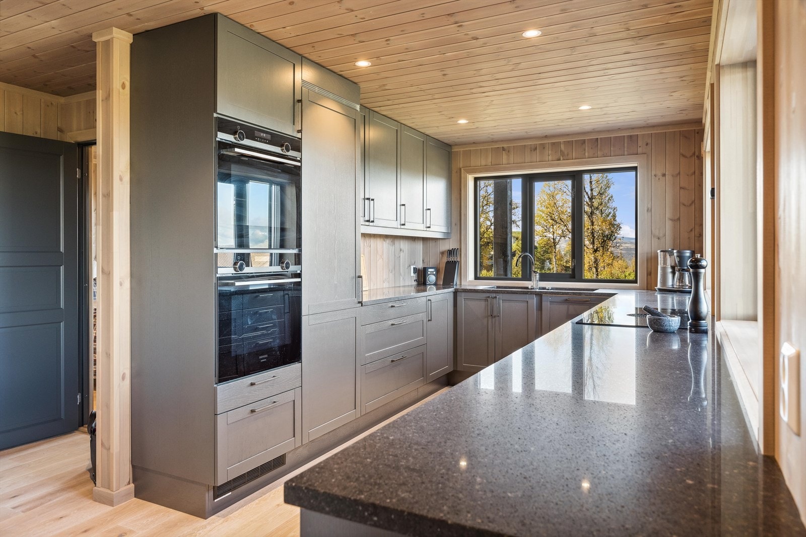 Flott innredningen med profilerte eike fronter og benkeplate i stein/kompositt med dobbel kjøkkenkum. Galleribilde