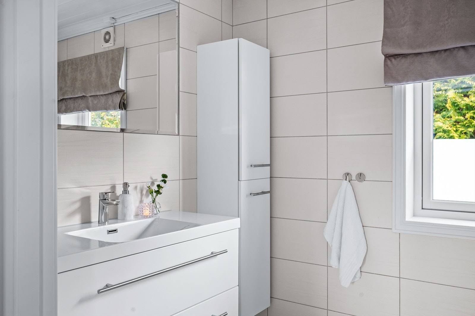 Badet har baderomsinnredning med heldekkende servant og speil på vegg, vegghengt wc og dusjkabinett. Galleribilde