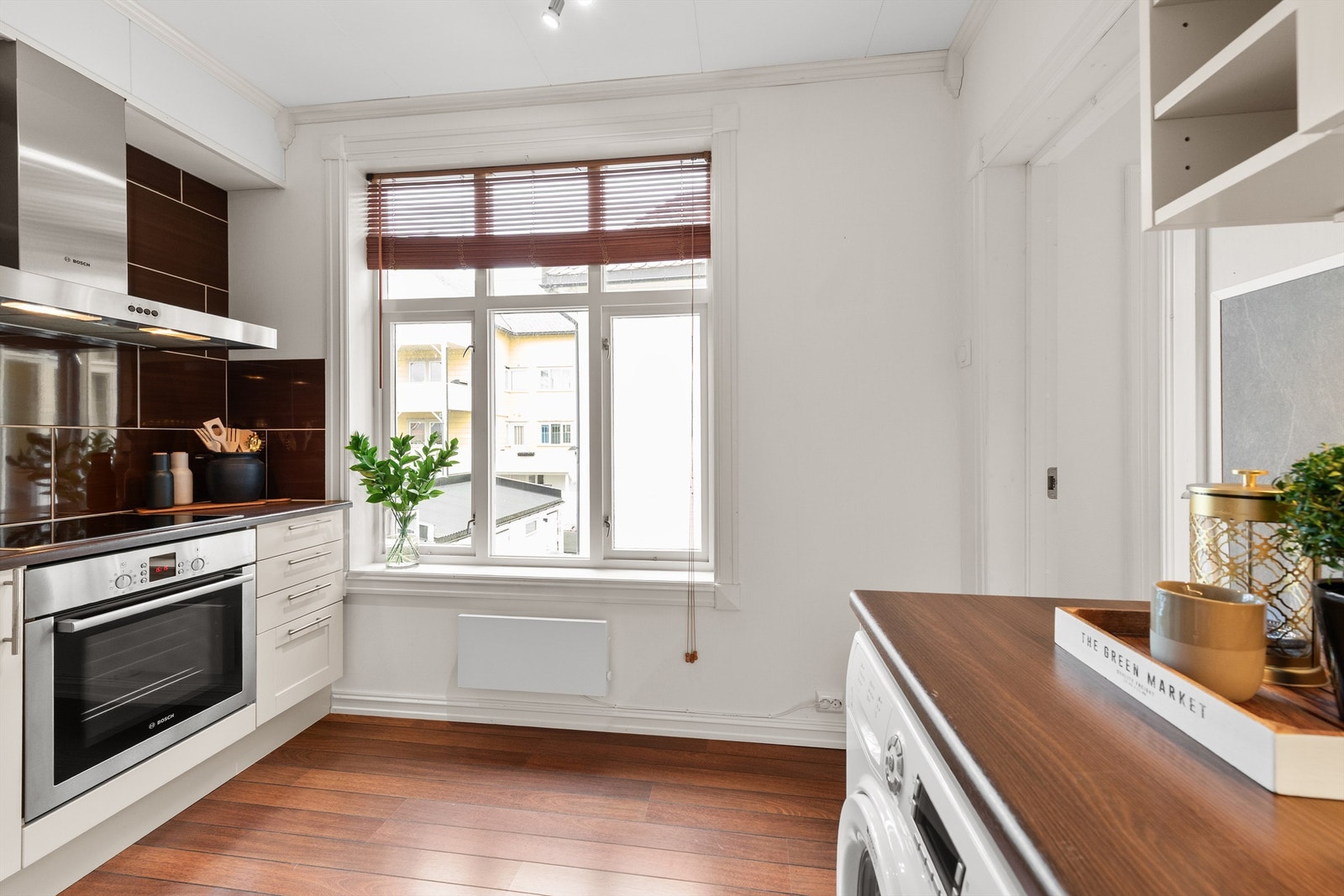 Lyst kjøkken med moderne innredning og store vinduer som gir rikelig med naturlig lys. Perfekt for matlaging og hygge. Galleribilde