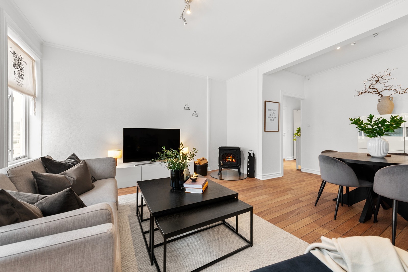 Lys og innbydende stue med moderne innredning. Peis gir en koselig atmosfære. Perfekt for avslapning og sosiale sammenkomster. Galleribilde