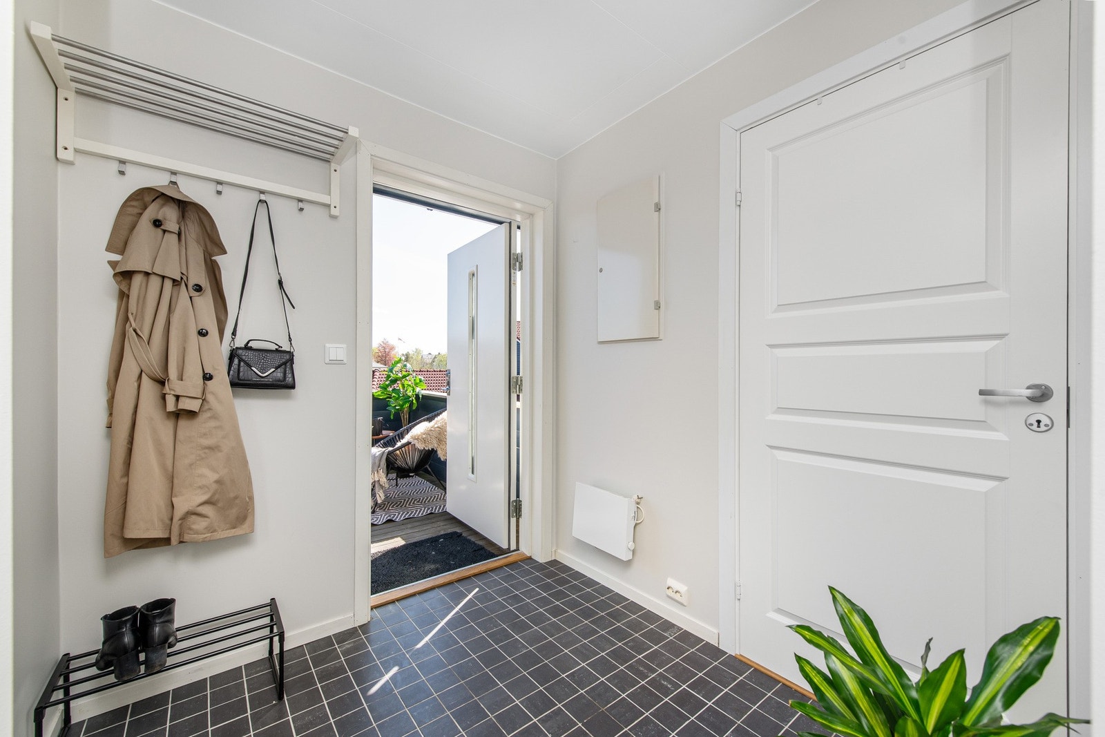 En romslig og innbydende entré med god plass til oppheng av yttertøy og oppbevaring. Galleribilde
