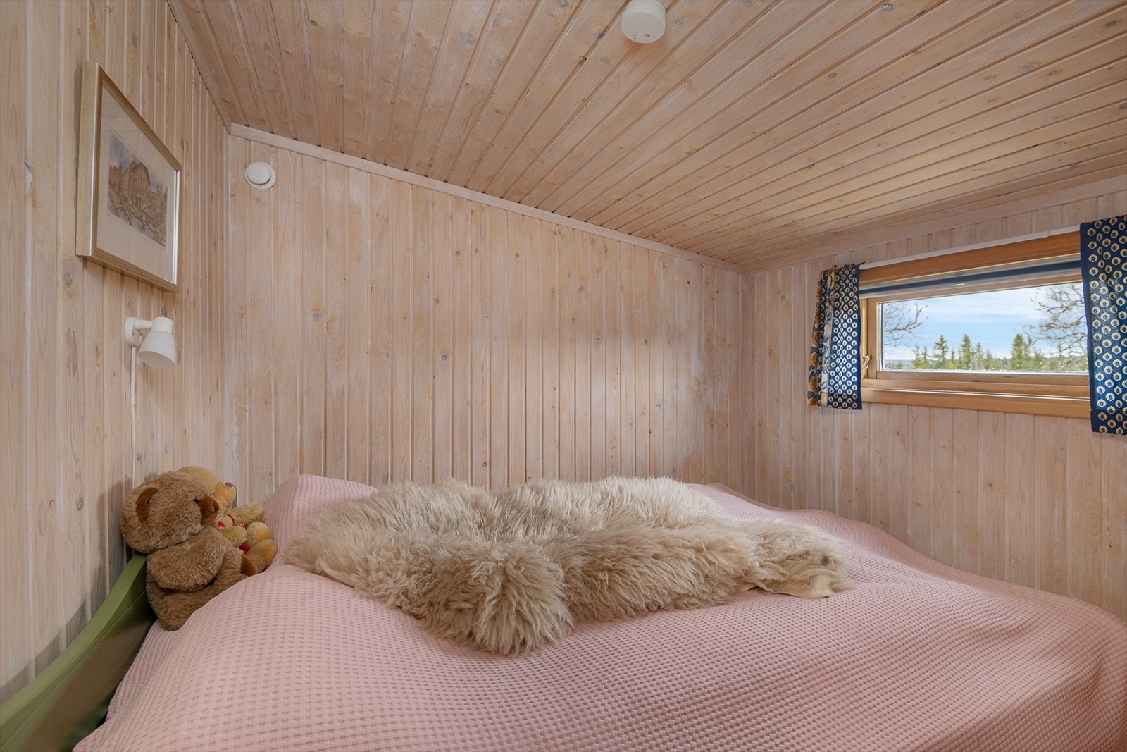 Soverom med panelte vegger og tak med hvitpigmentering. Innredet med dobbeltseng. Galleribilde