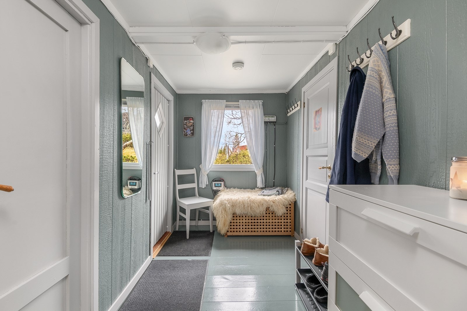 Romslig gang med god plass til å henge fra seg yttertøy og utstyr. Herfra er det dør inn til bod med utedo og vedbod. Galleribilde