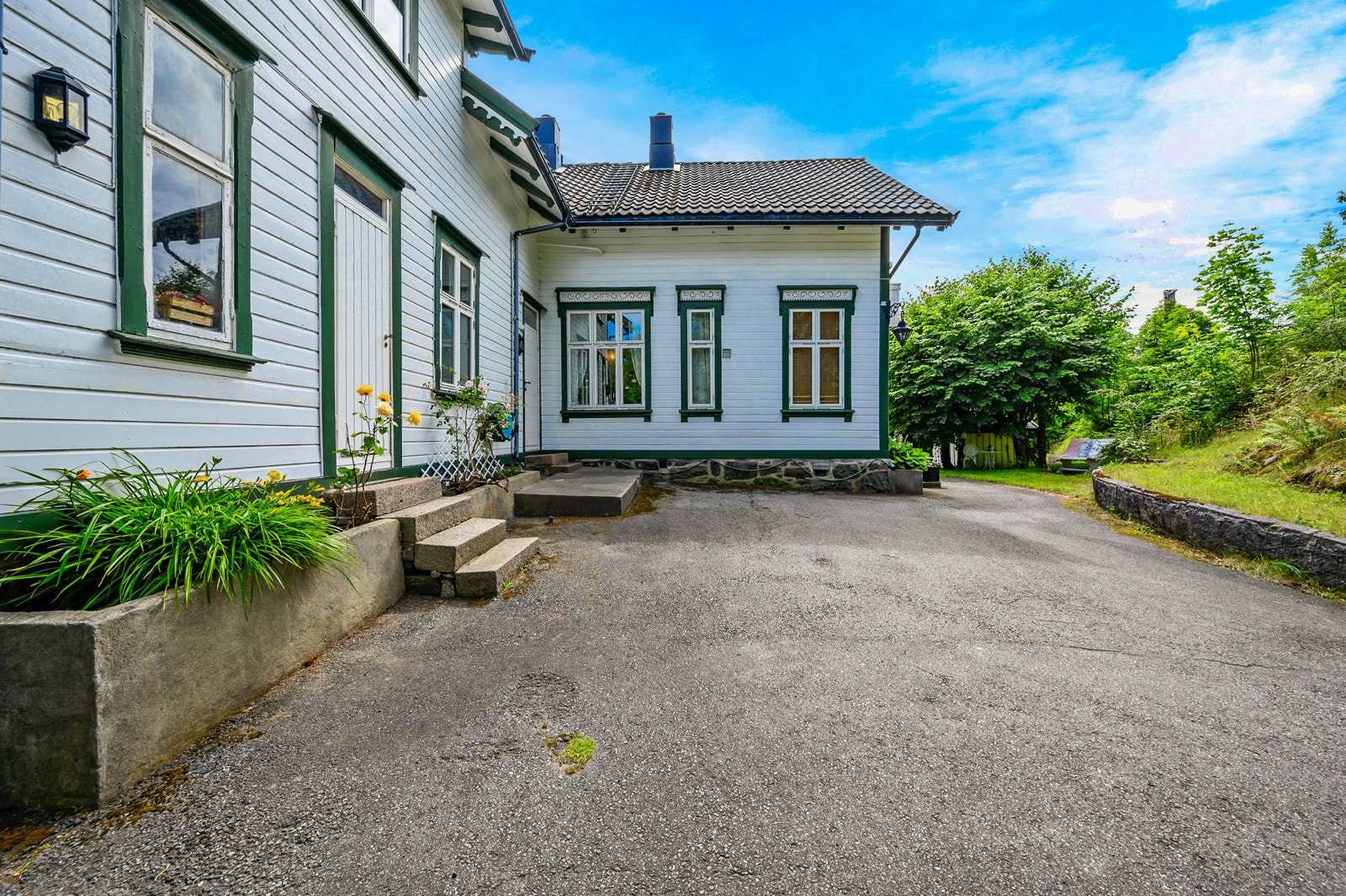 Den asfalterte oppkjørselen foran huset gir et ryddig førsteinntrykk samtidig som den byr på gode parkeringsmuligheter Galleribilde