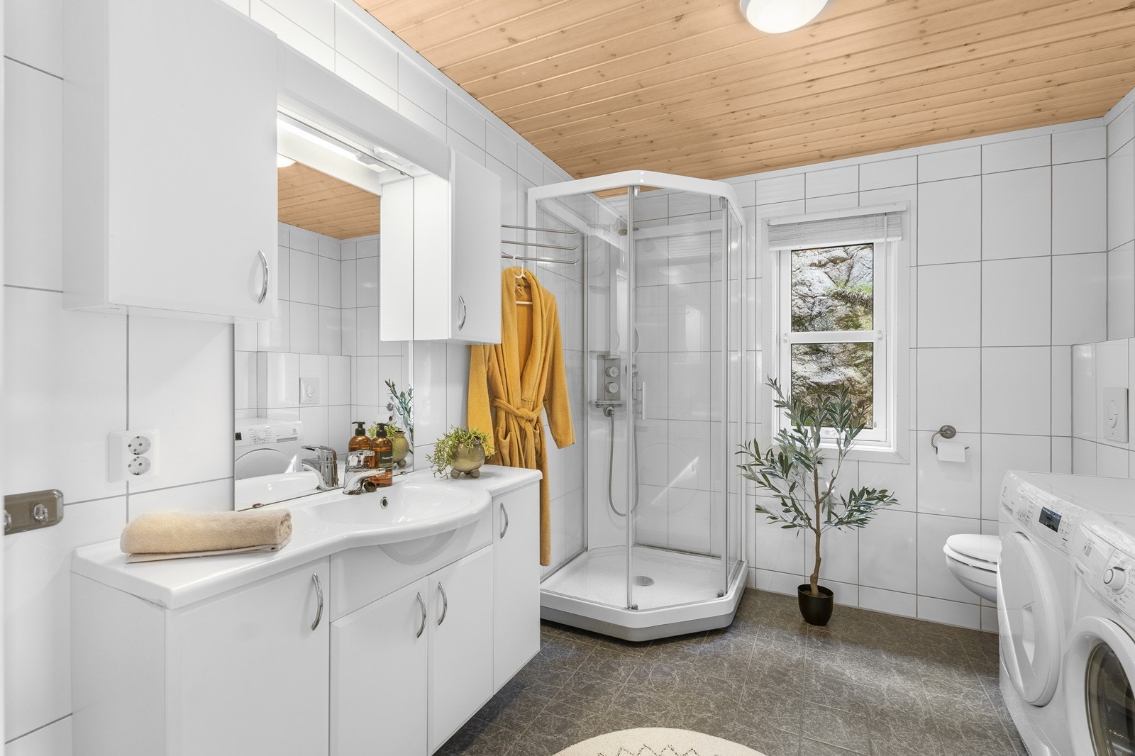 Romslig bad med fliser på gulv og vegg. Det er varmekabler. Galleribilde