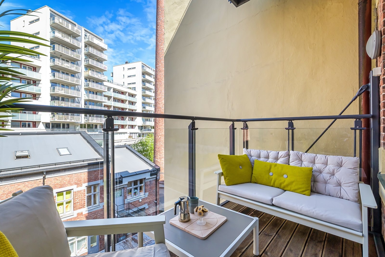 Rillede terrassebord over betong på gulv, glassrekkverk og utvendig stikkontakt/belysning Galleribilde