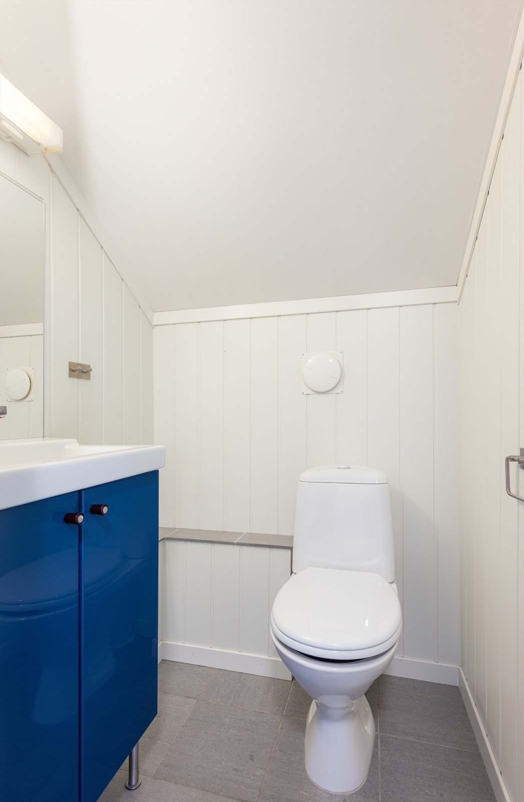 Adskilt toalettrom i 2. etasje som innehar toalett og servantinnredning med underskap og speil. Galleribilde