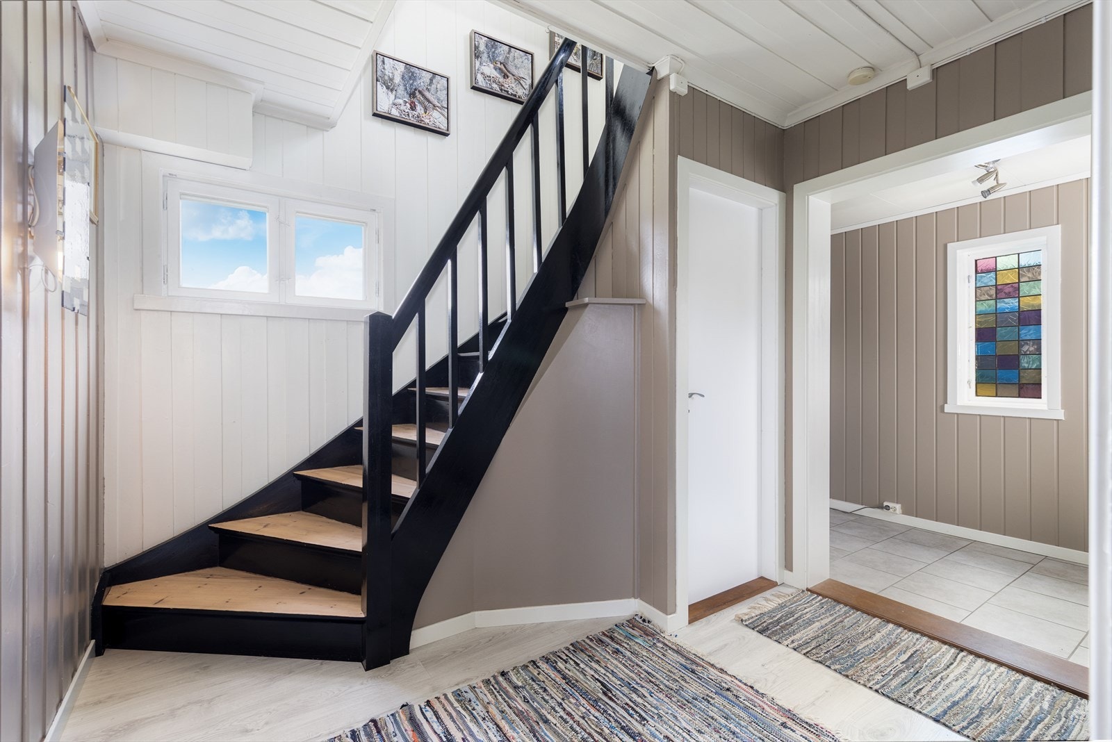 Hyggelig entré med varmekabler i gulv og flislagt overflate. Videre er det inn i en fin mellomgang med god plass til oppbevaring i skyvedørsgarderobe med speildører. Trapp til 2. etasje og tilkomst til stue og kjøkken. Galleribilde