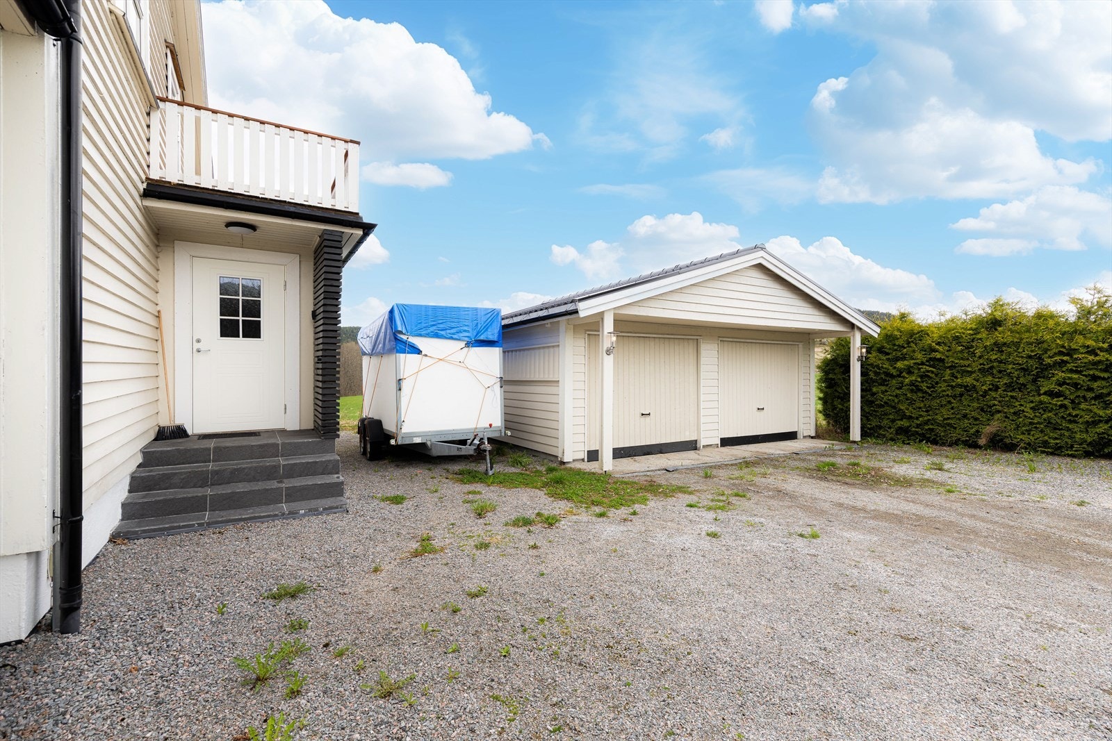Eiendommen har en stor, gruset gårdsplass med plass til flere biloppstillingsplasser og parkering i dobbelt garasje. Det er installert elbillader. Galleribilde