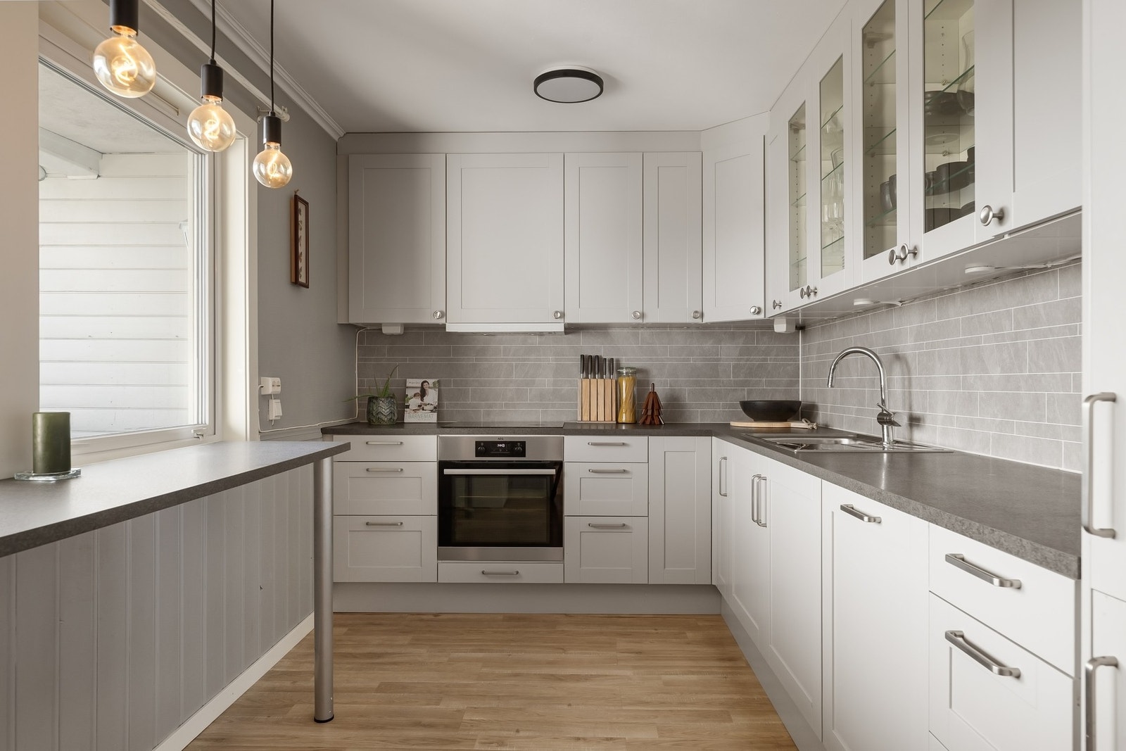 Lyst og pent kjøkken med god oppbevaringsplass i skap og skuffer. Galleribilde