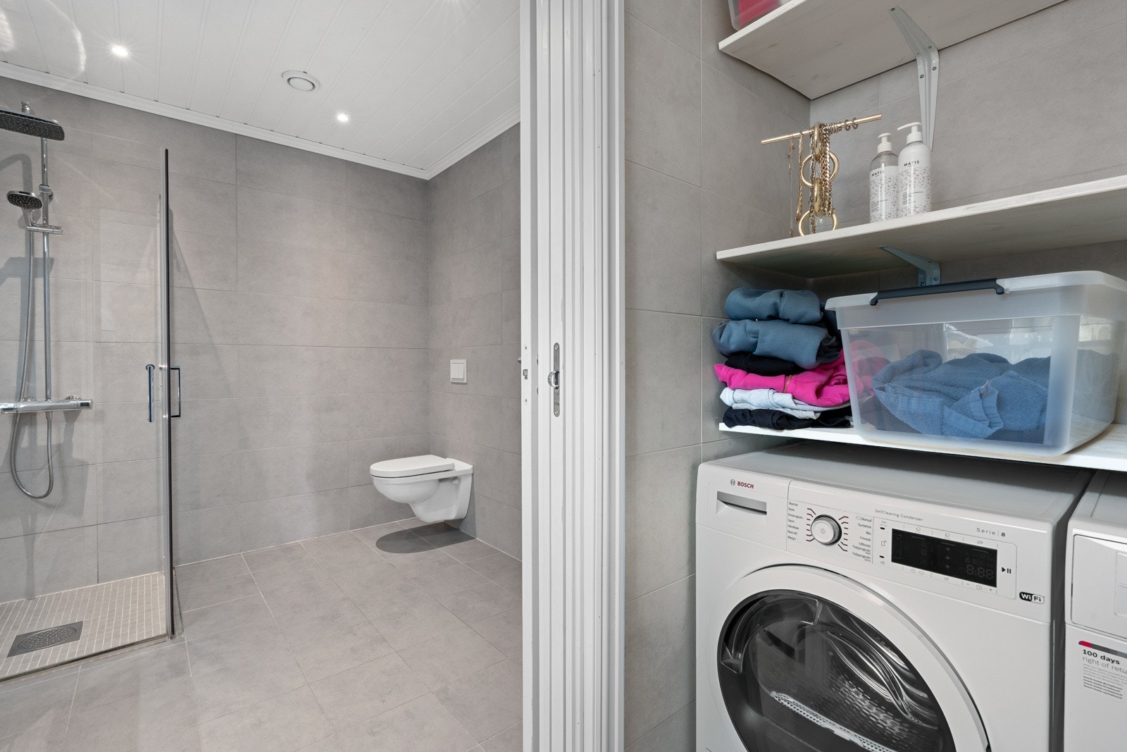 Fra hovedbadet er det adkomst til boligens vaskerom via plassbesparende skyvedør. Galleribilde