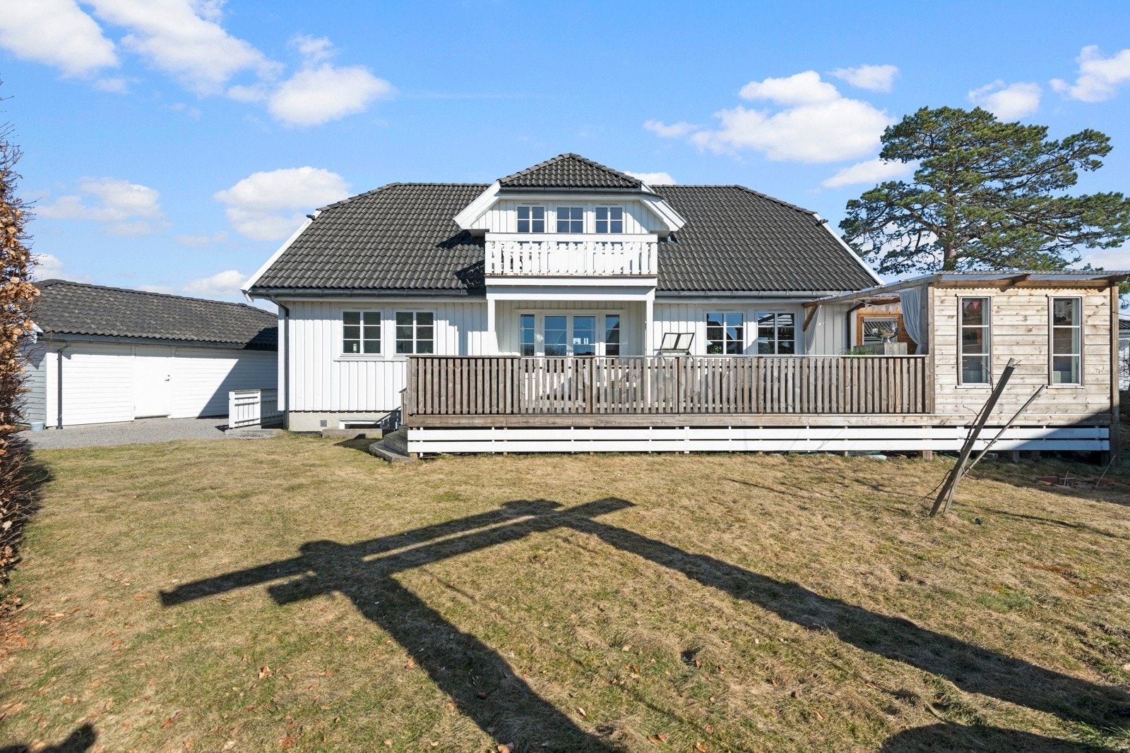 Den usjenerte terrassen fremstår som en naturlig forlengelse av stuen i sommerhalvåret, og gir ekstra rom for å nyte solfylte og varme finværsdager utendørs. Galleribilde