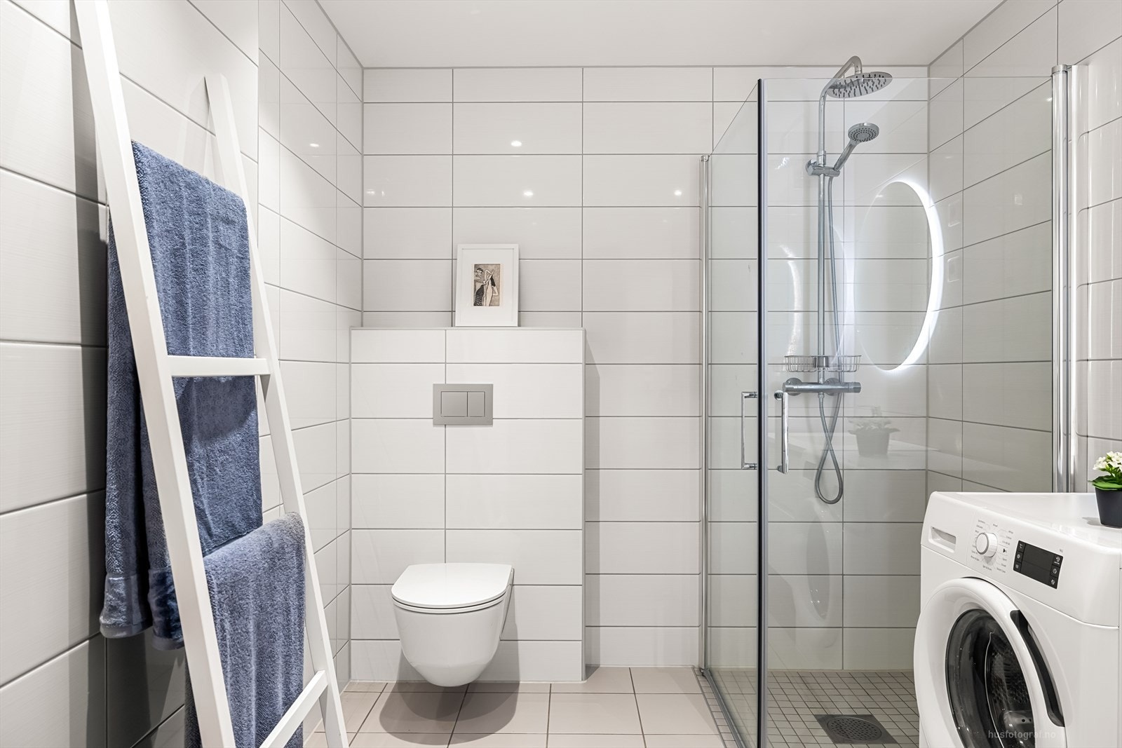 Badet er innredet med heldekkende nedfelt servant med rom for oppbevaring i skuffer, speil med led lys, vegghengt toalett og dusjhjørne med innfellbare dusjvegger. Galleribilde