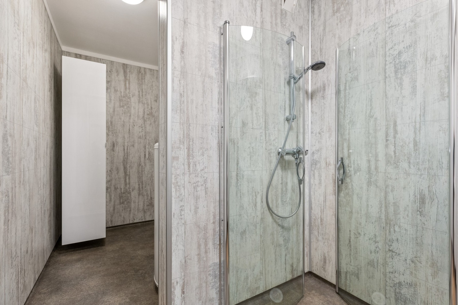 Badet har dusjhjørne med dører og fin vegghengt servantinnredning. Galleribilde