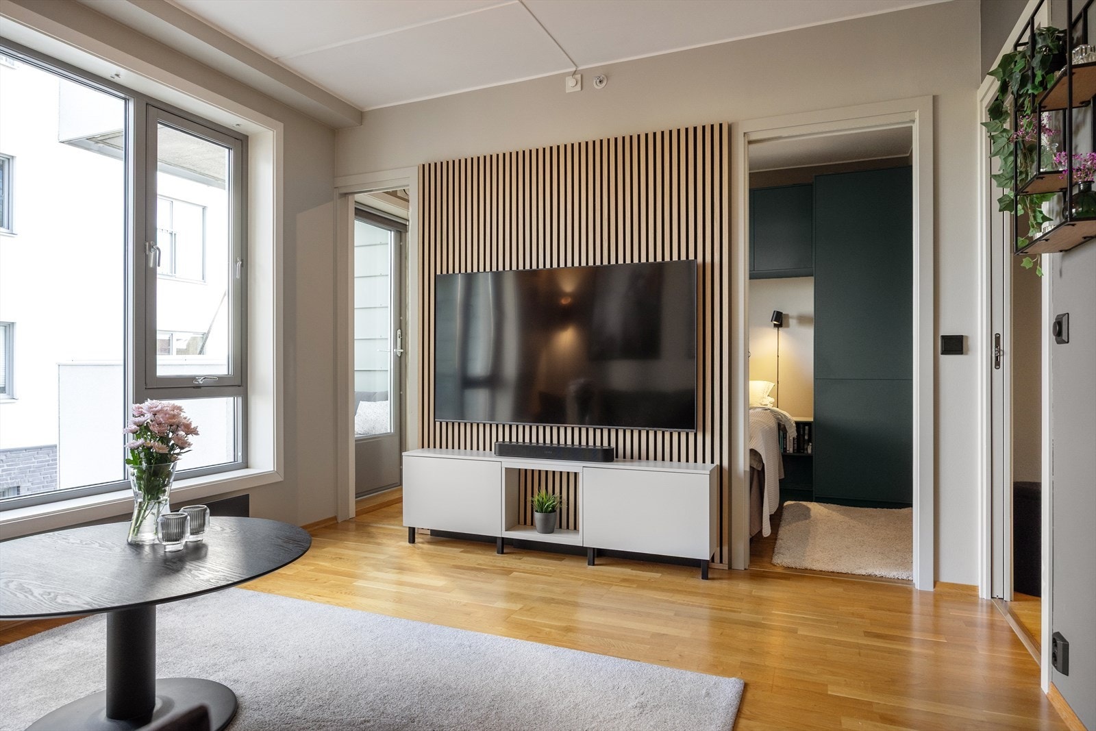 Boligen er sparklet og malt med harmoniske farger som speiler naturen utenfor. Tanken var å skape en sømløs overgang mellom det grønne utemiljøet og interiøret, slik at stuen nesten får en forlengelse inn blant trærne. Galleribilde