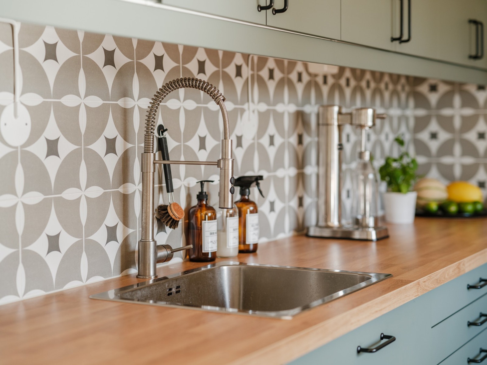 Flislagt mellom kjøkkenbenk og overskap samt benkskapsbelysning og stikkontakter under overskap. Galleribilde