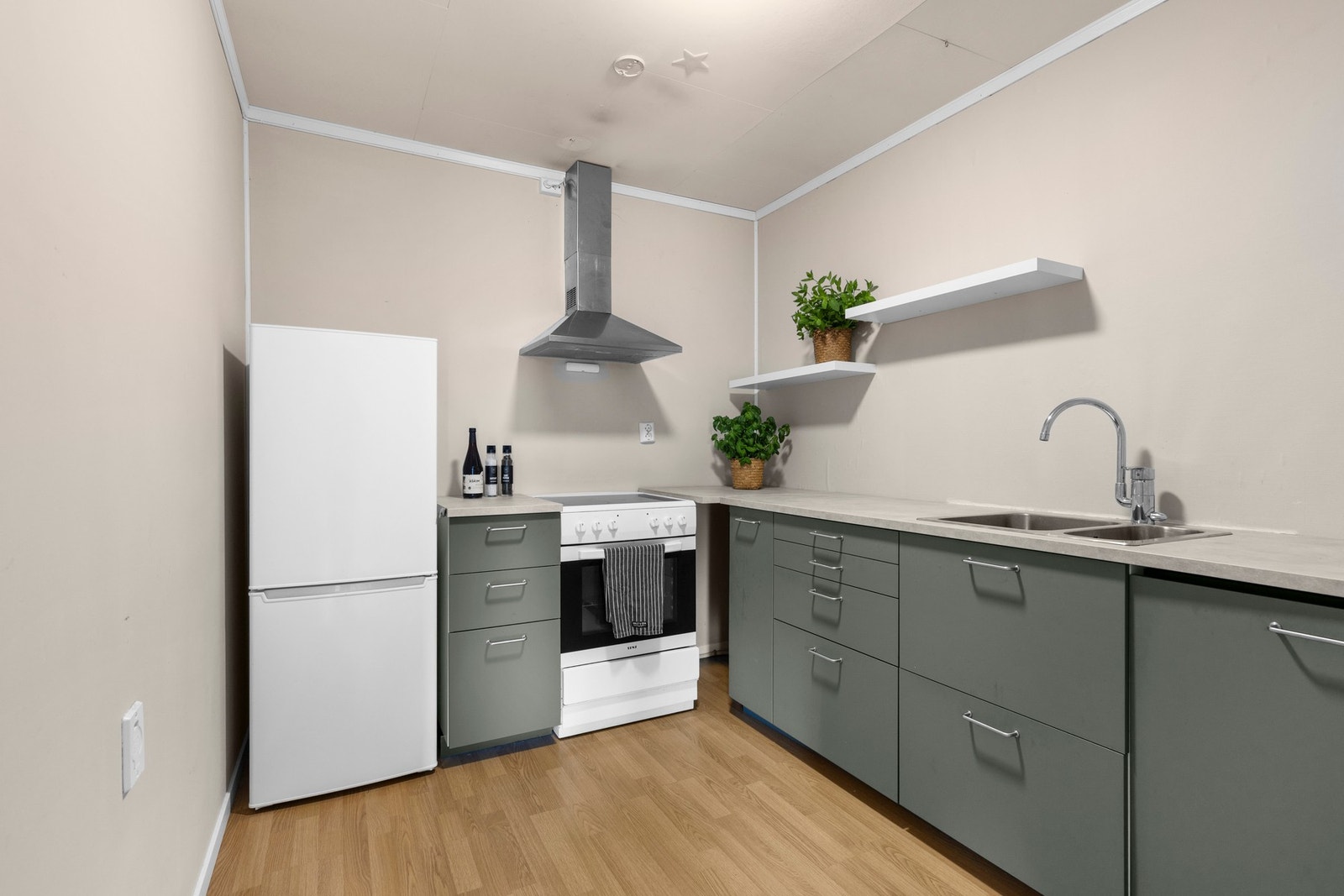 Kjøkkeninnredning fra 2020 med slette fronter og benkeplate med laminert overflate og nedfelt oppvaskkum i rustfritt stål med ettgreps armatur. Galleribilde
