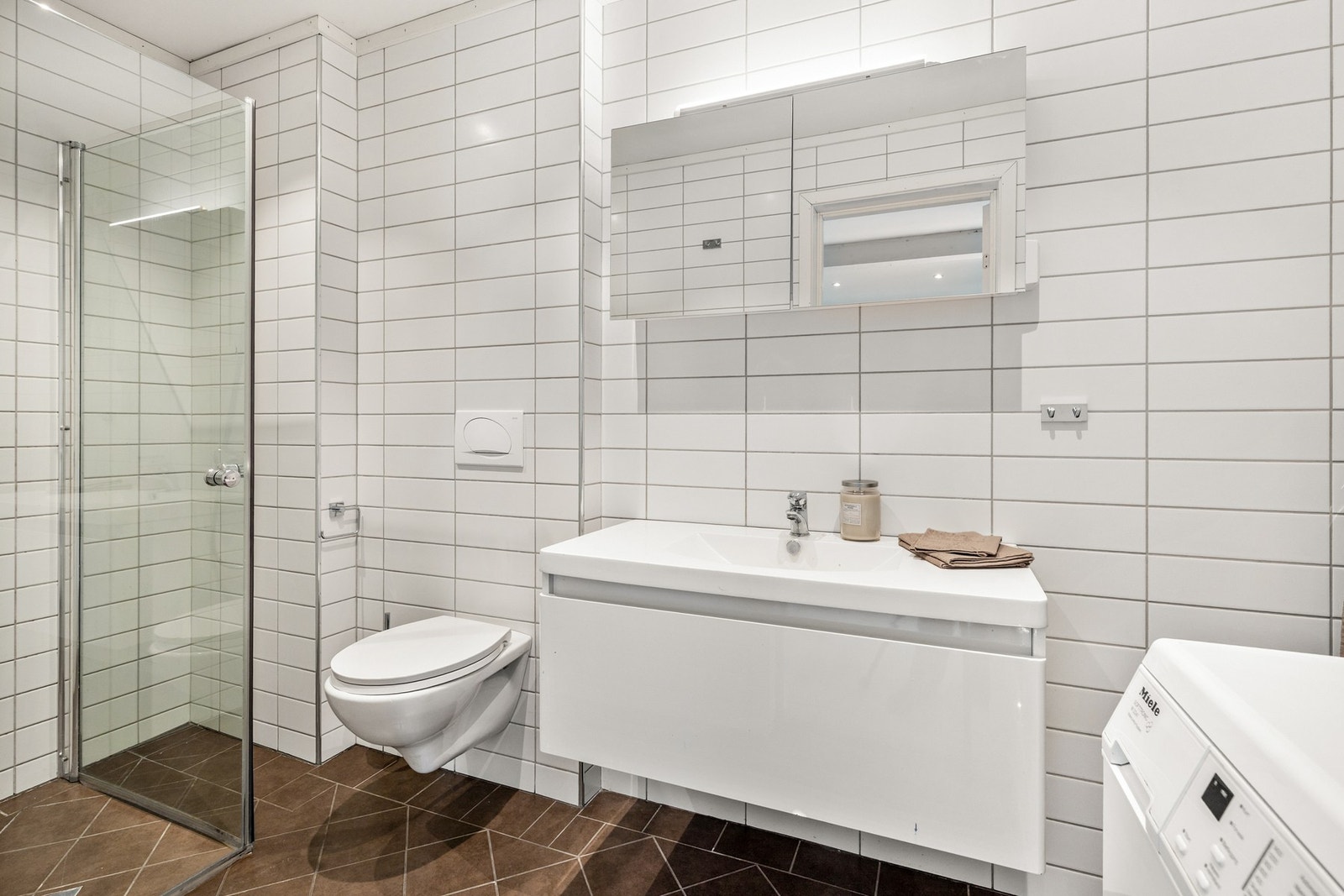 Bad fra ca. 2008 med flislagt gulv med gulvvarme og flislagte vegger. Himlingen består av malt, slett flate med innfelte downlights. Galleribilde