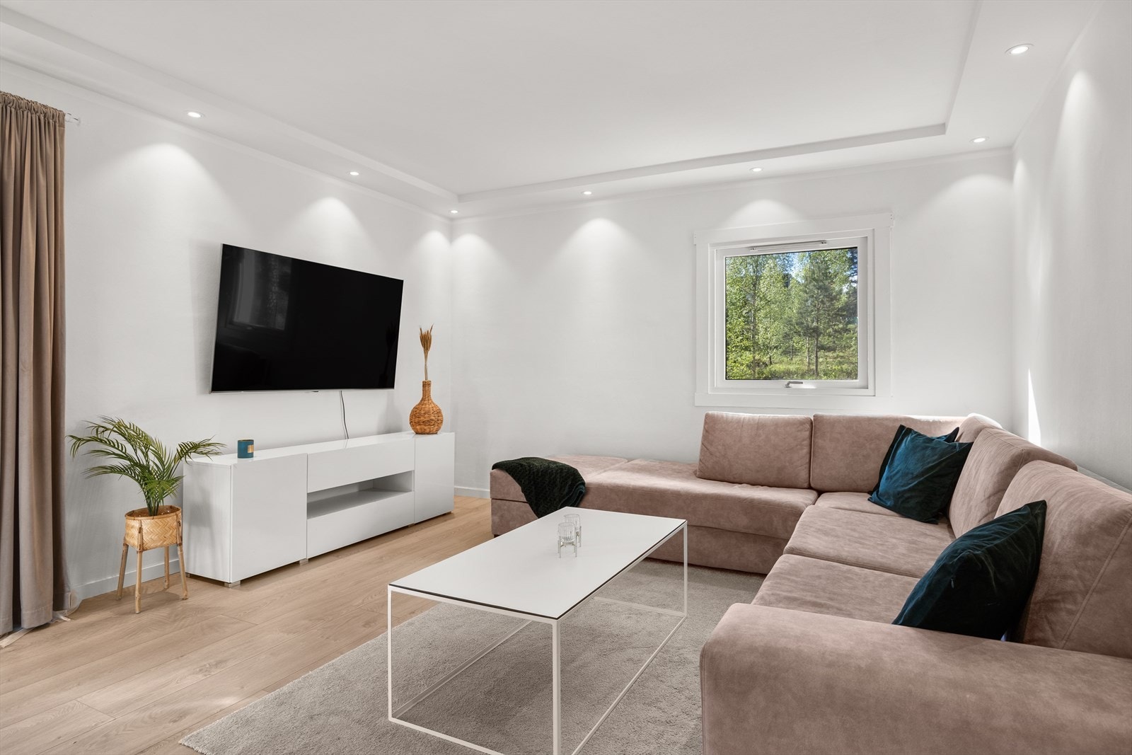 Svært romslig stue med hvitmalte vegger og rikelig med naturlig lys. Galleribilde