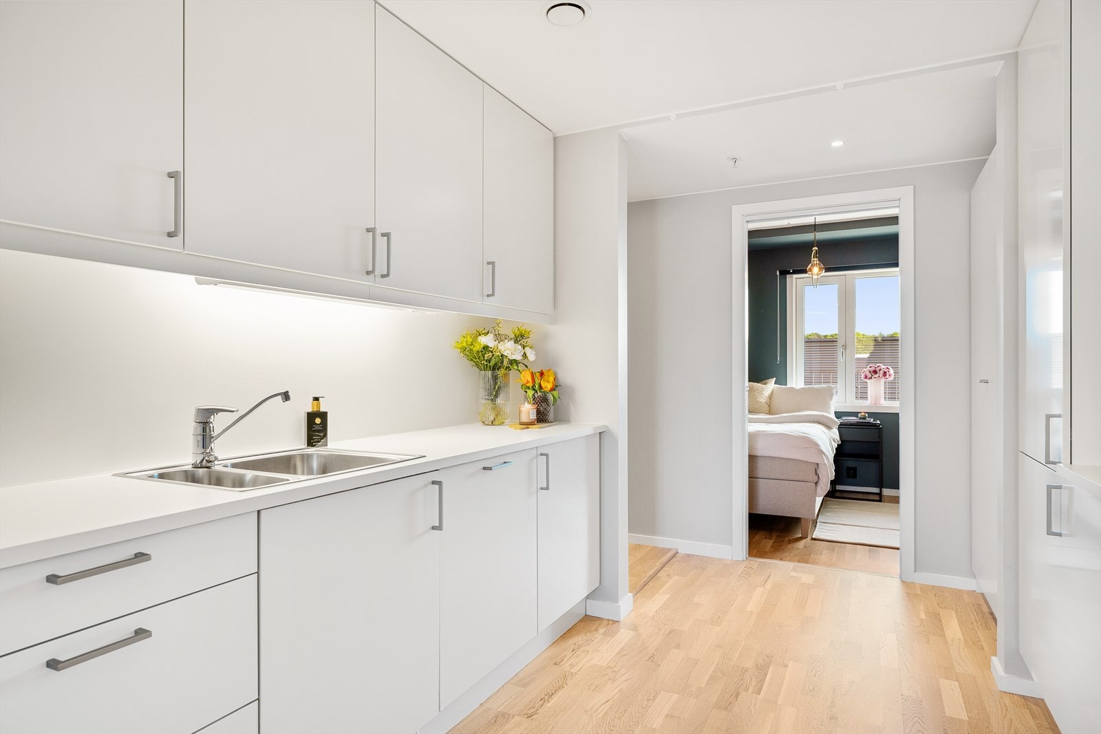 Kjøkkeninnredning med glatte fronter. Belysning under overskap. Galleribilde