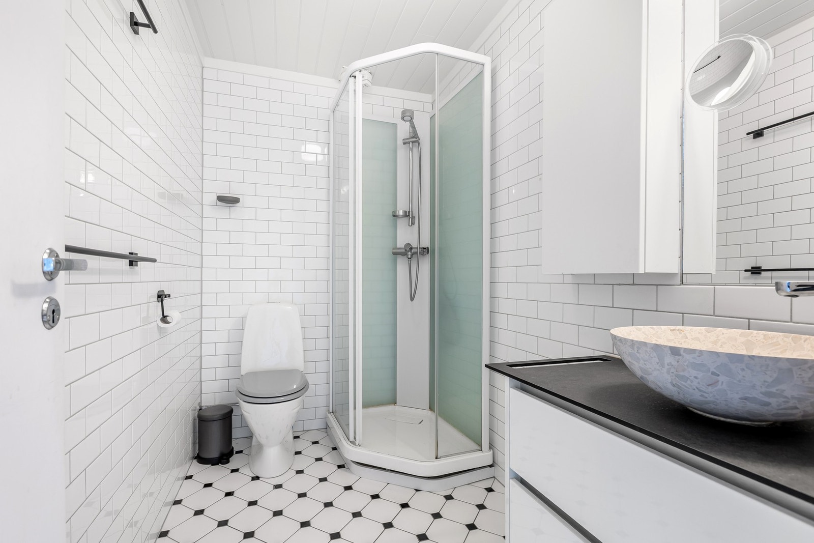 Badet er innredet med dusjkabinett og nyere baderomsinnredning med toppmontert vask og wc Galleribilde