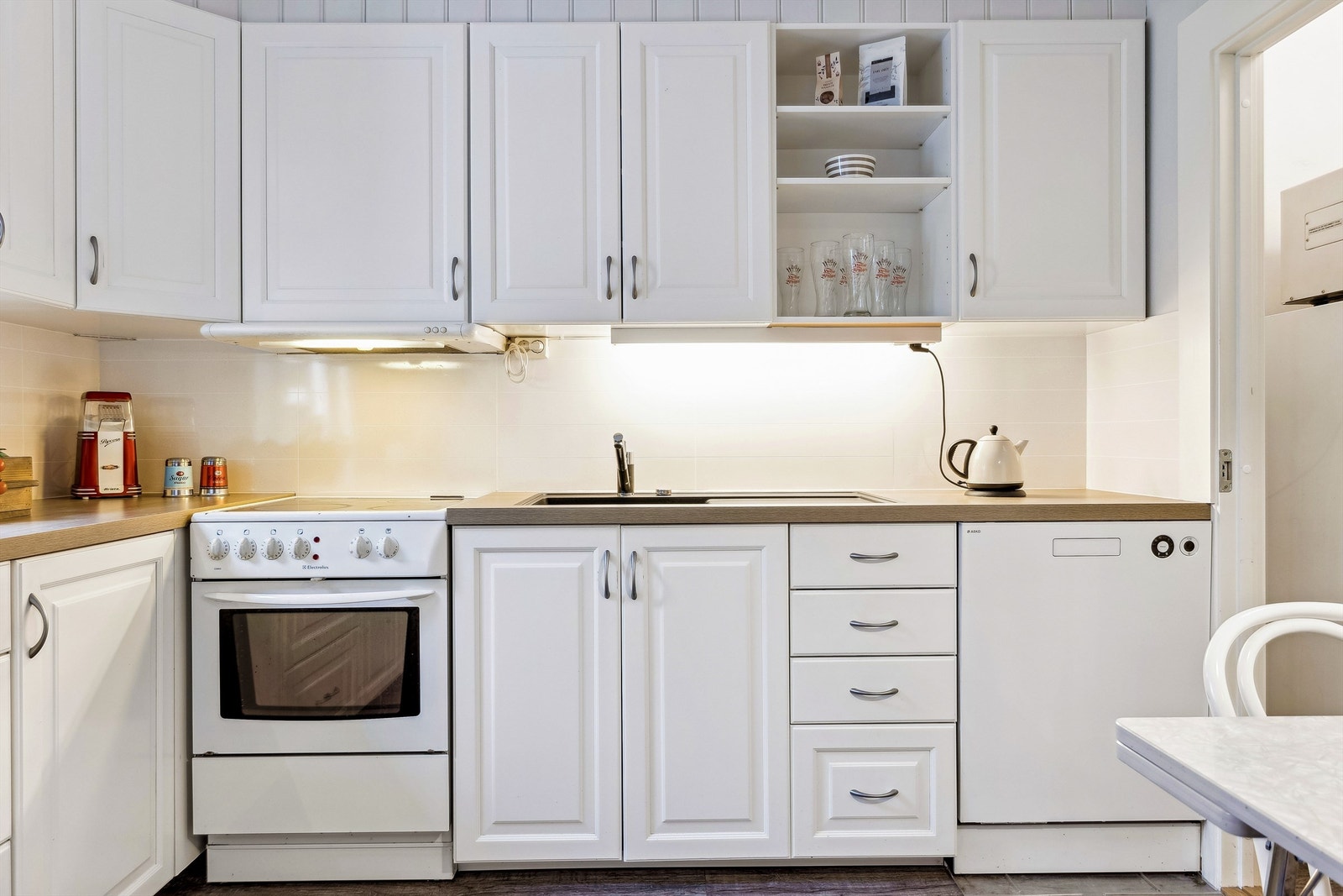 Klassisk innredning med plass til frittstående hvitevarer. Opplegg til oppvaskmaskin. Galleribilde