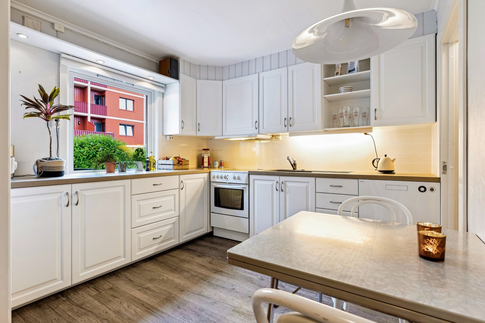 Kjøkkenet er bygget over to sider, med nedfelt vaskekum om fliser i benkerygg. Godt med skapplass. Galleribilde