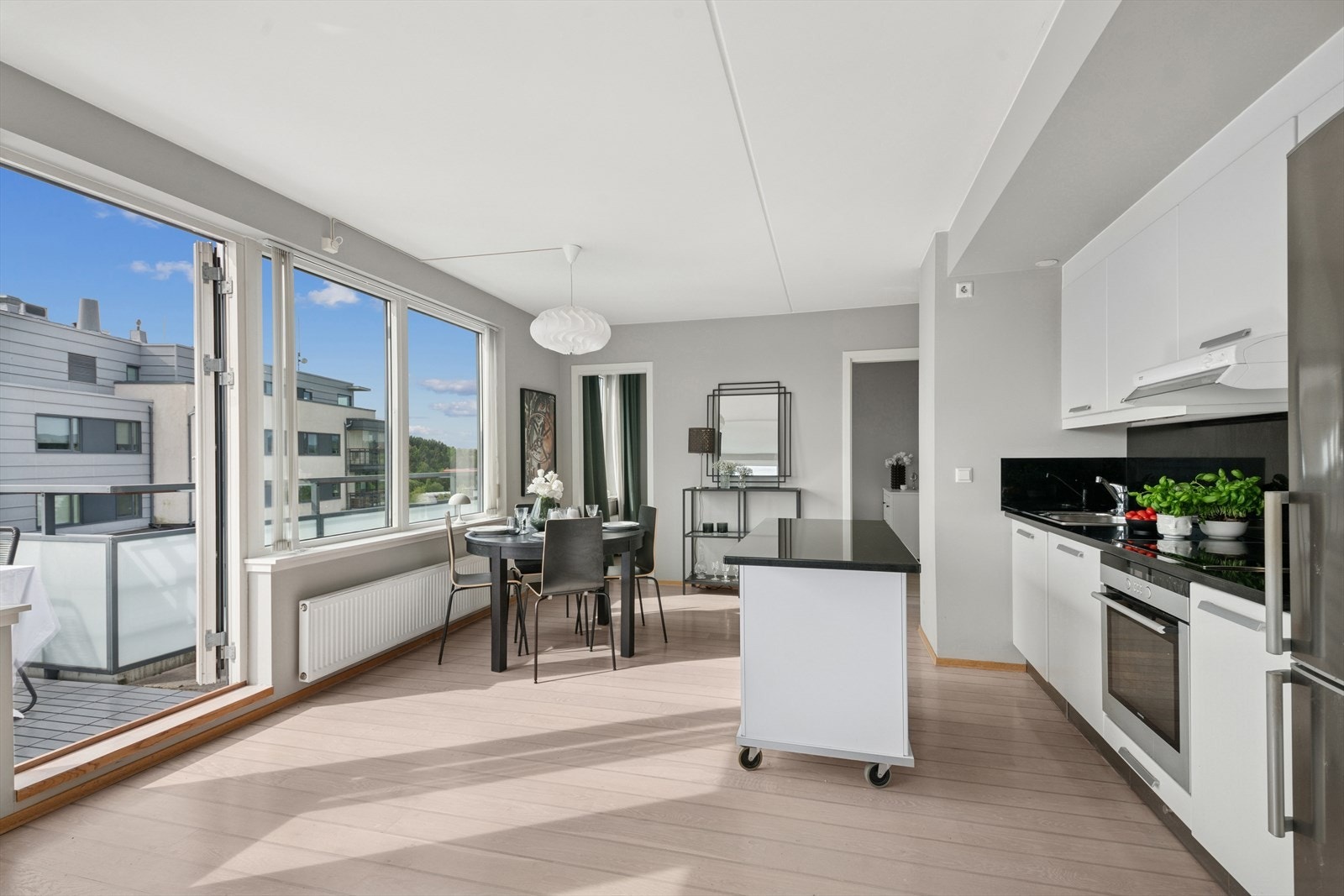 Det er parkett på gulv. Stuen er malt i en lys gårtone. Galleribilde