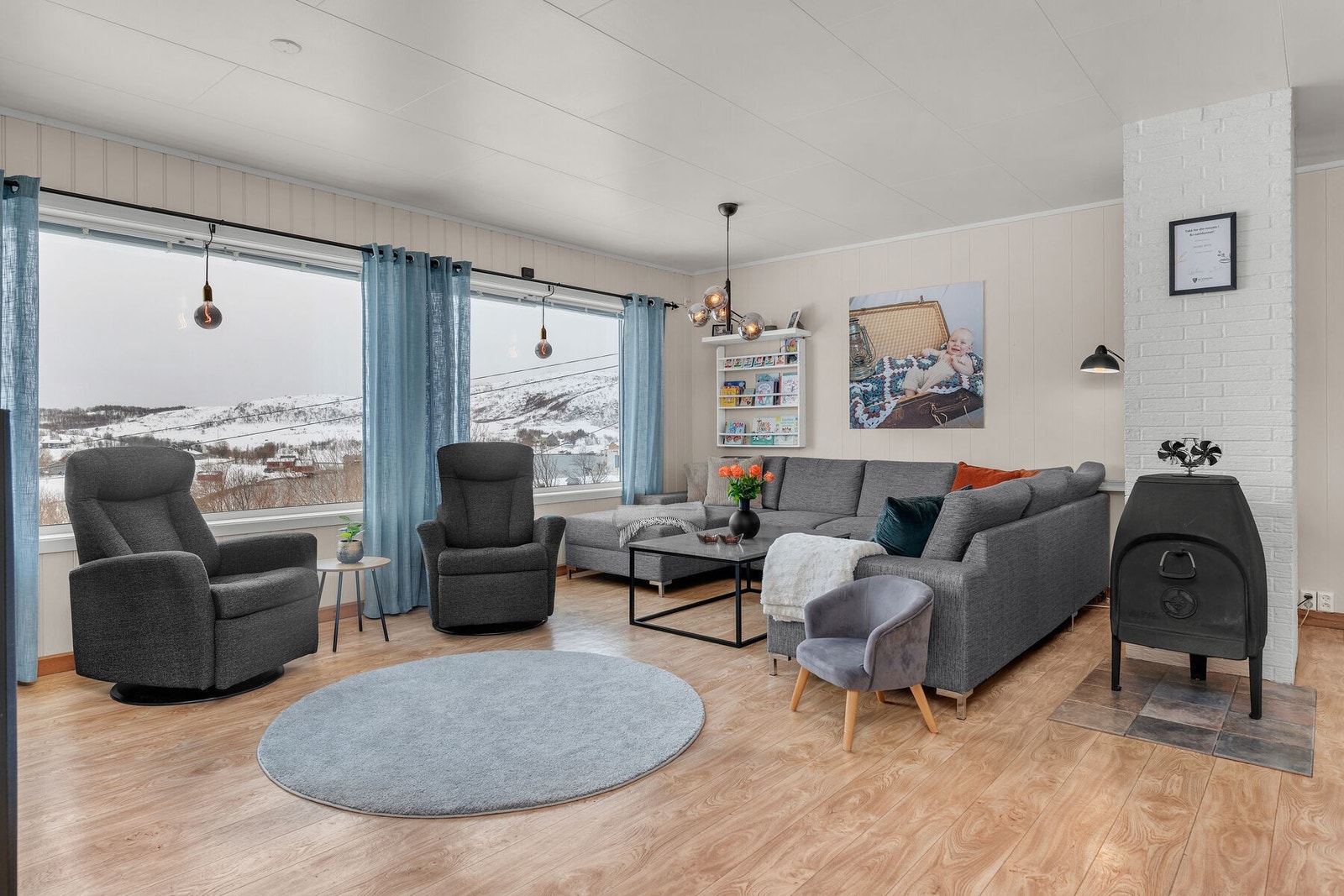 Romslig stue med god plass for møblering, store vinduer i front og vedovn Galleribilde