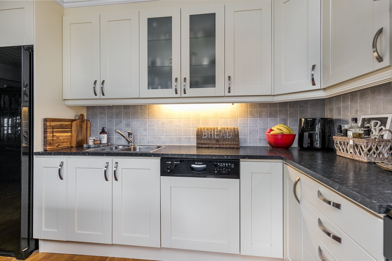 Kjøkkenet er utformet i praktisk vinkelform og har rikelig med skap og benkeplass. Kjøkkeninnredning med profilerte og folierte fronter. Galleribilde