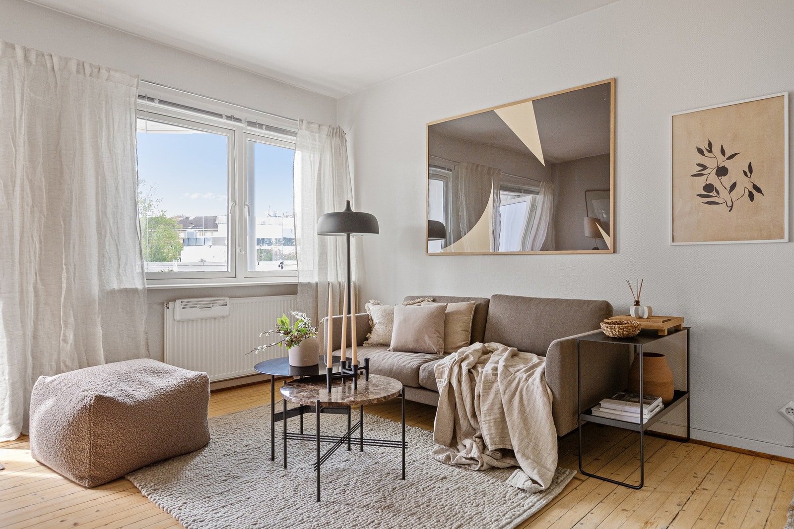 Lys stue med furugulv og overflater av malt tapet. Galleribilde