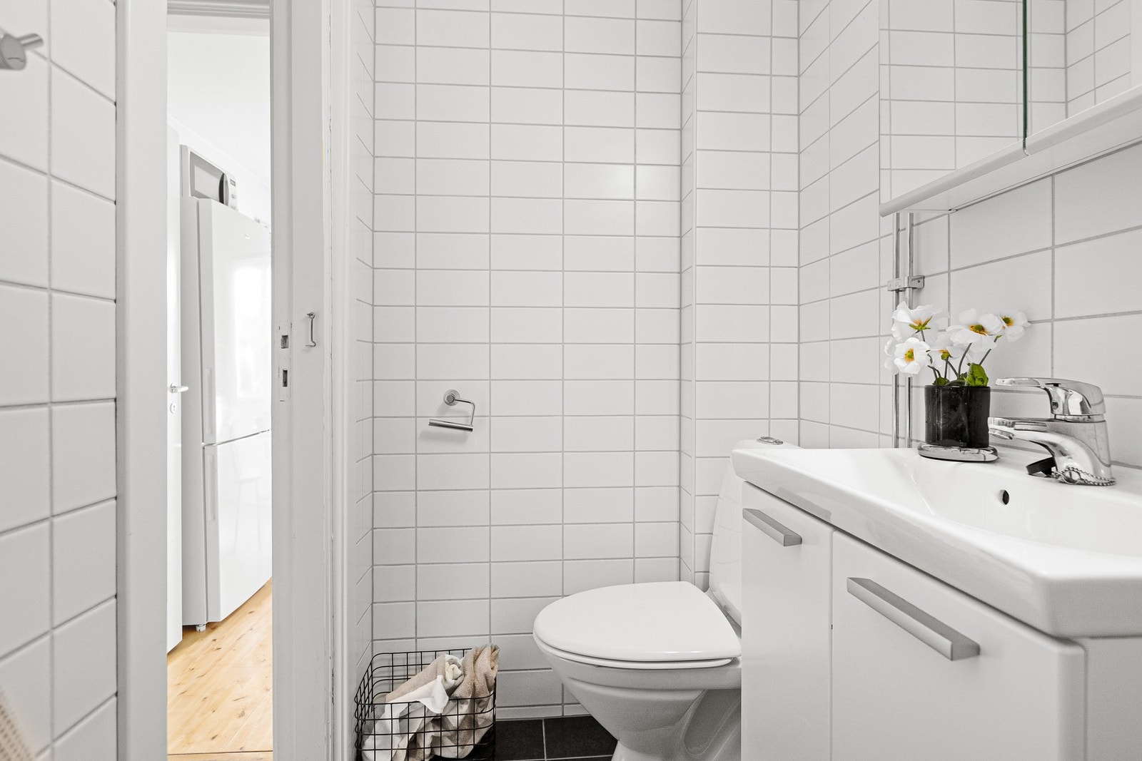 Inneholder servant med underskap og speil, dusjhjørne med skyvedører og frittstående toalett. Galleribilde