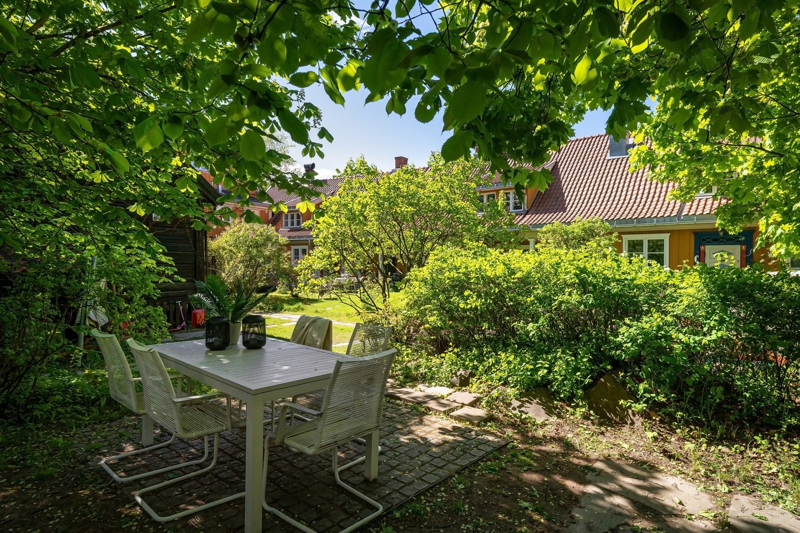 Eiendommen ligger på en høyde, og har en nydelig felleshage mot syd og øst. Hagen har store plenarealer og bugner av blomstrende prydvekster, klatreplanter, busker og ærverdige trær som skaper en frodig idyll. Galleribilde