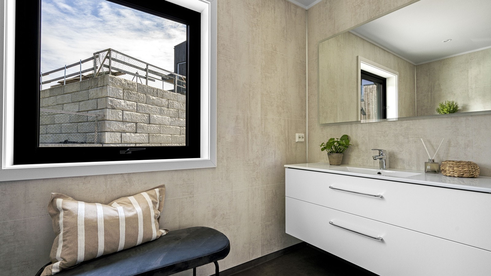 Badet er utstyrt med servantinnredning, speil med lys, toalett og dusjhjørne Galleribilde